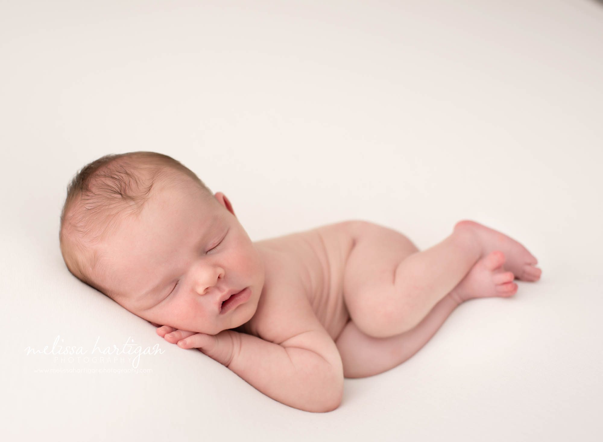 newborn baby boy posed on side on cream backdrop newborn photography CT
