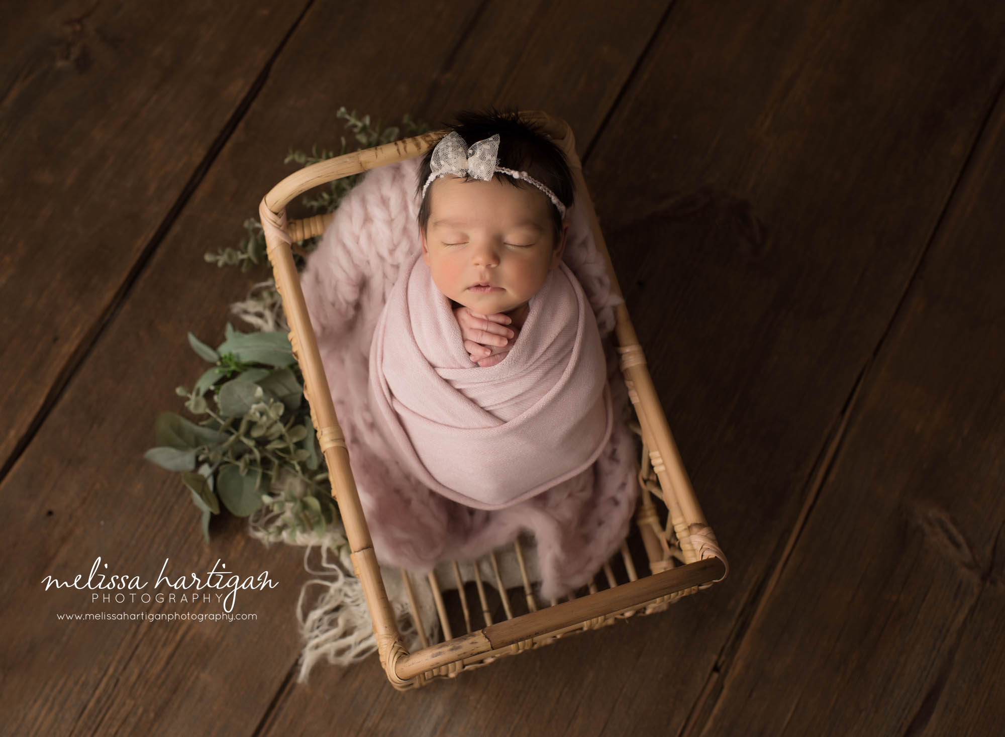 newborn baby girl wrapped in pink wrap posed in basket CT newborn photographer