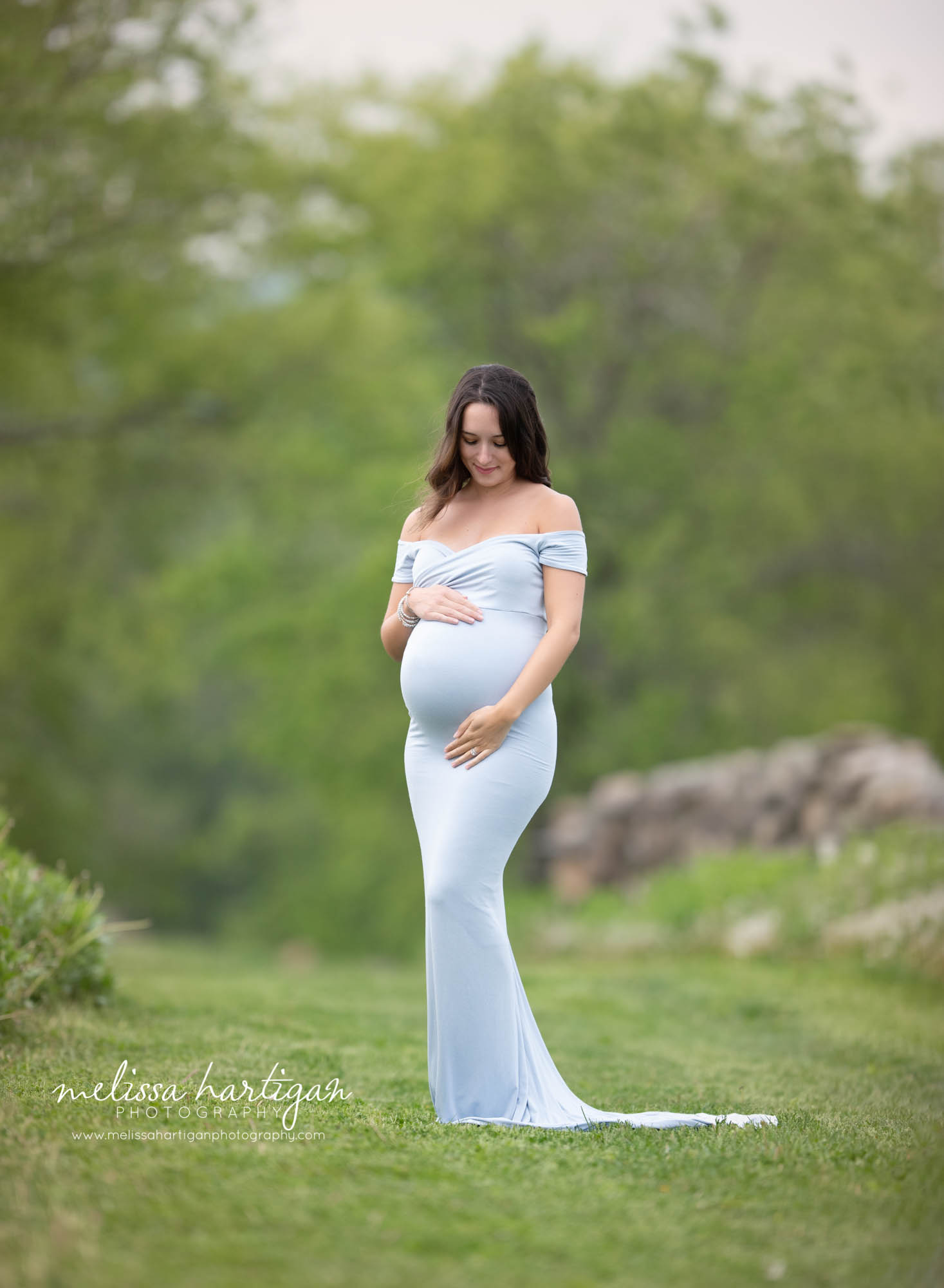pregnant mom-to-be wearing light blue long form fitted maternity dress holding baby bump maternity photographer connecticut pregnancy session