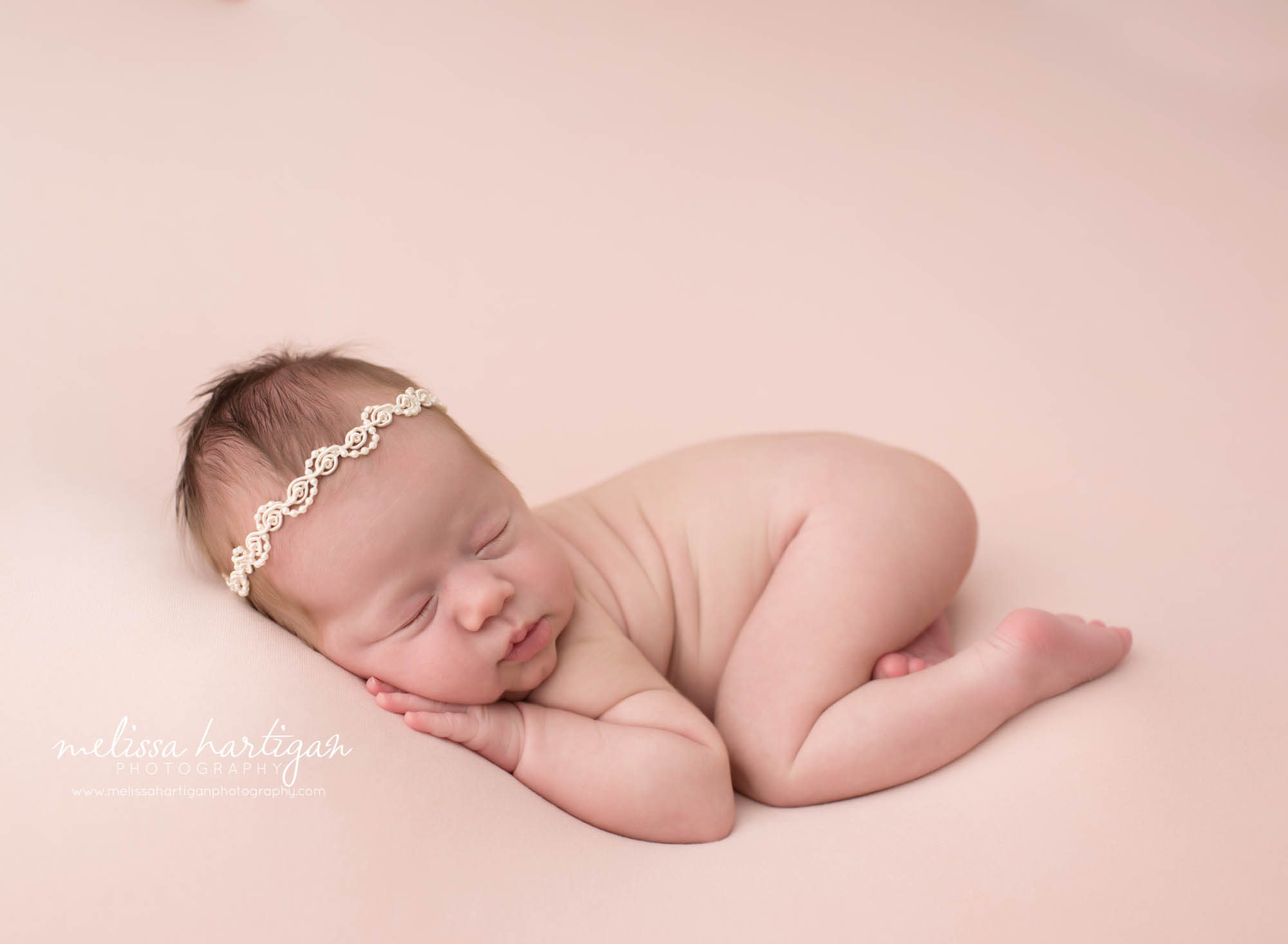 newborn baby girl posed on pink backdrop on tummy with hand under cheek windsor locks ct newborn photography