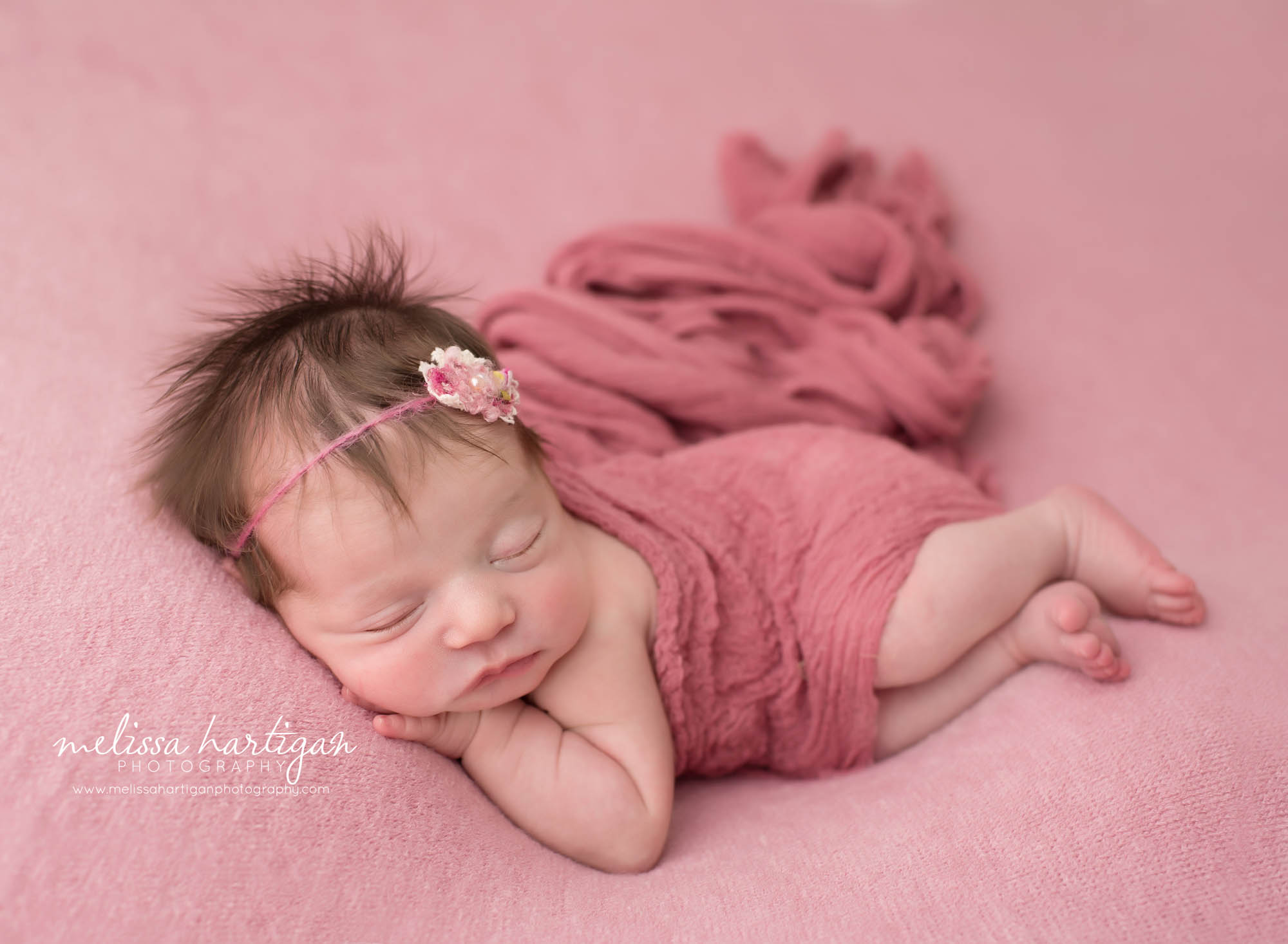 newborn baby girl posed on side with pink wrap wearing pink headband CT maternity newborn photography