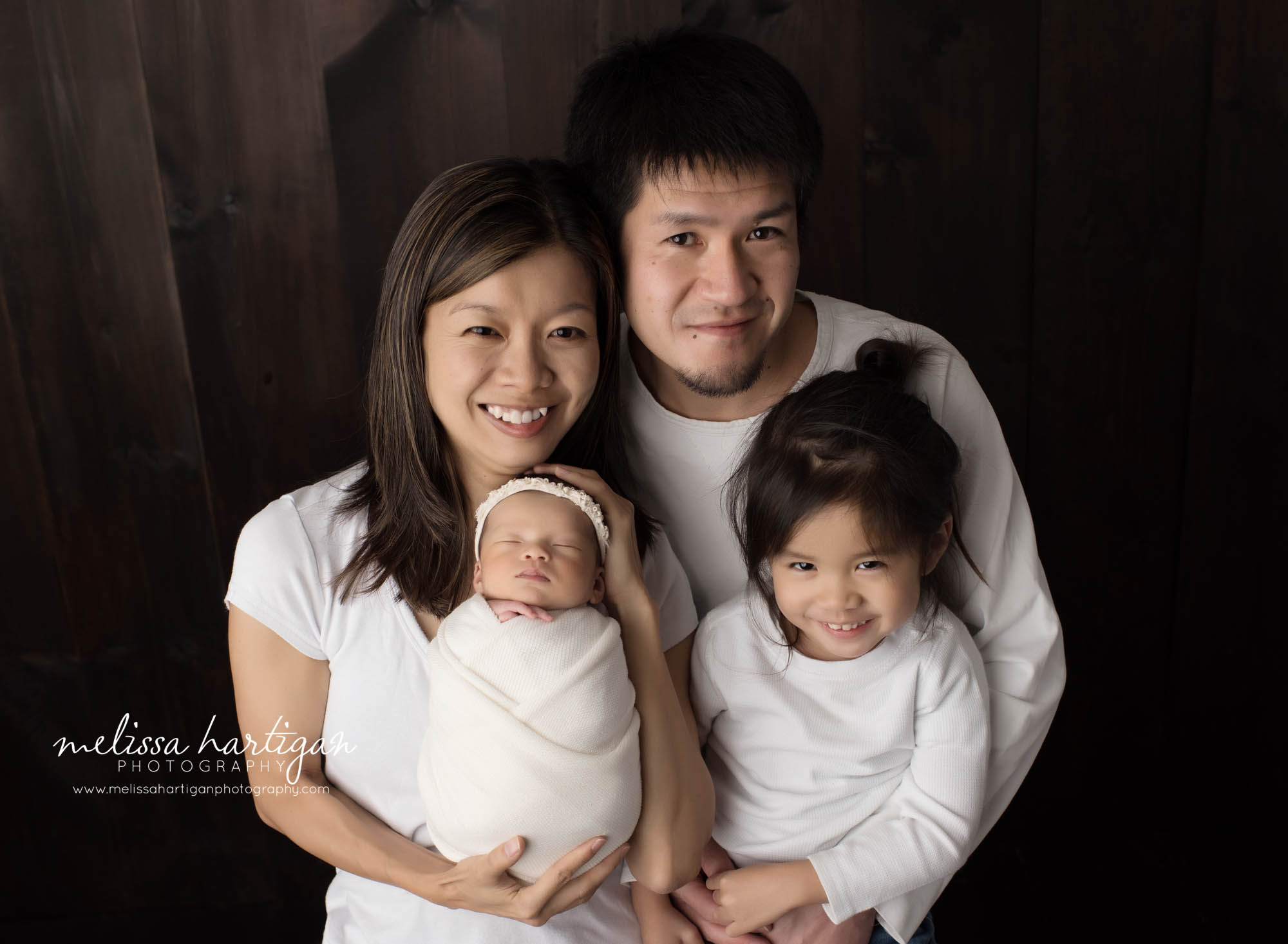 mom dad big brother and baby girl posed together for family pose newborn photography photoshoot