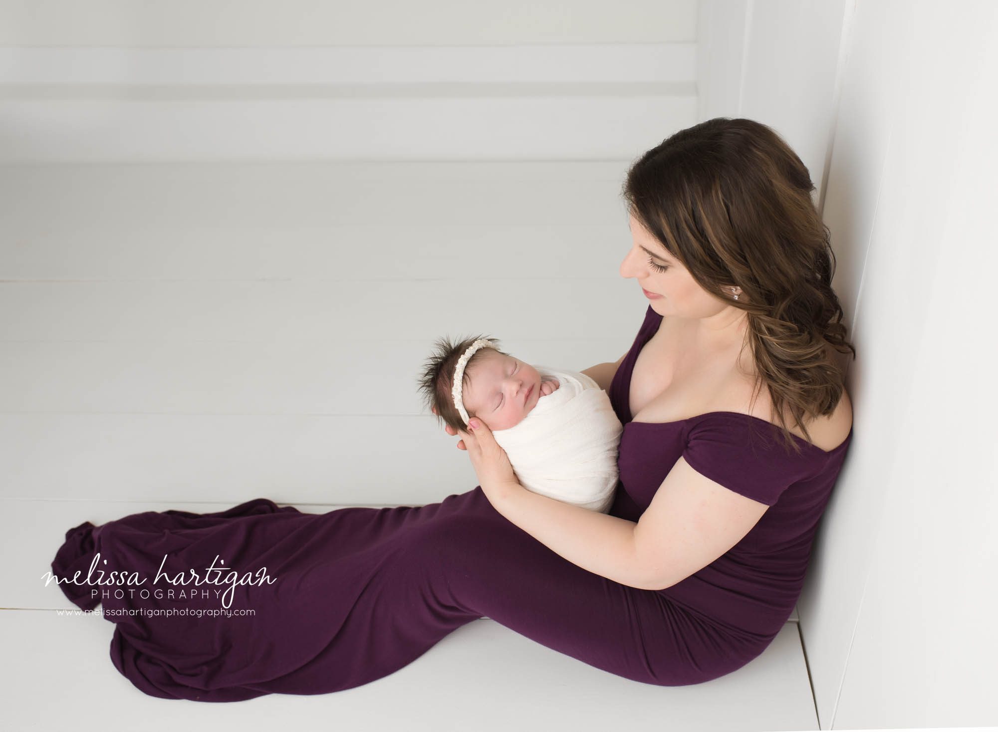 mom holding newborn baby daughter parent pose sitting down