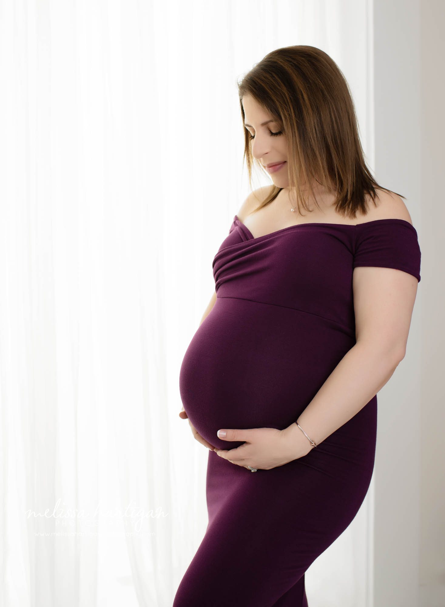 expectant mom holding baby bump studio maternity photography