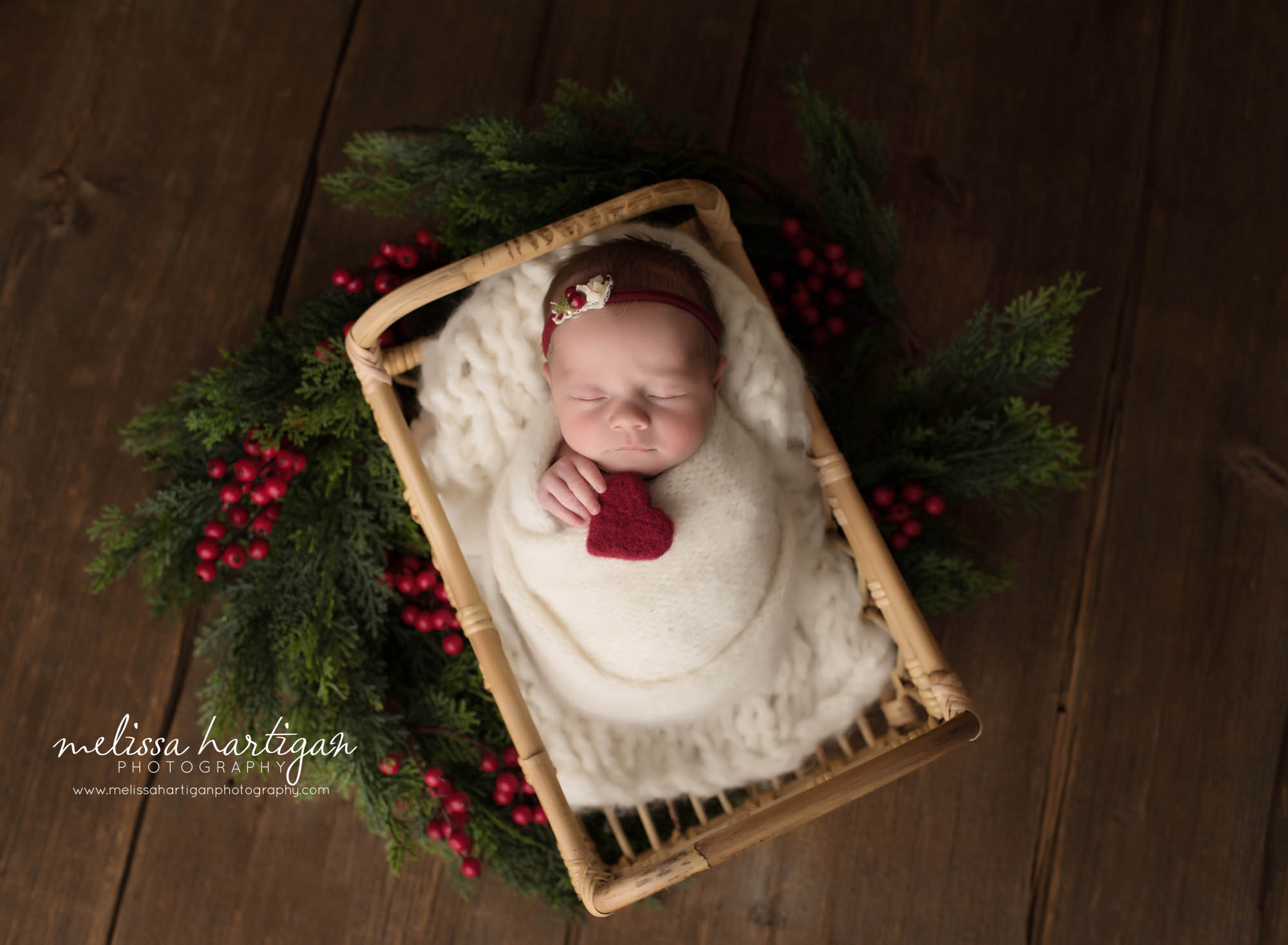 newborn baby girl posed in baket wrapped in white knitted layer holding red felted heart connecticut newborn photography