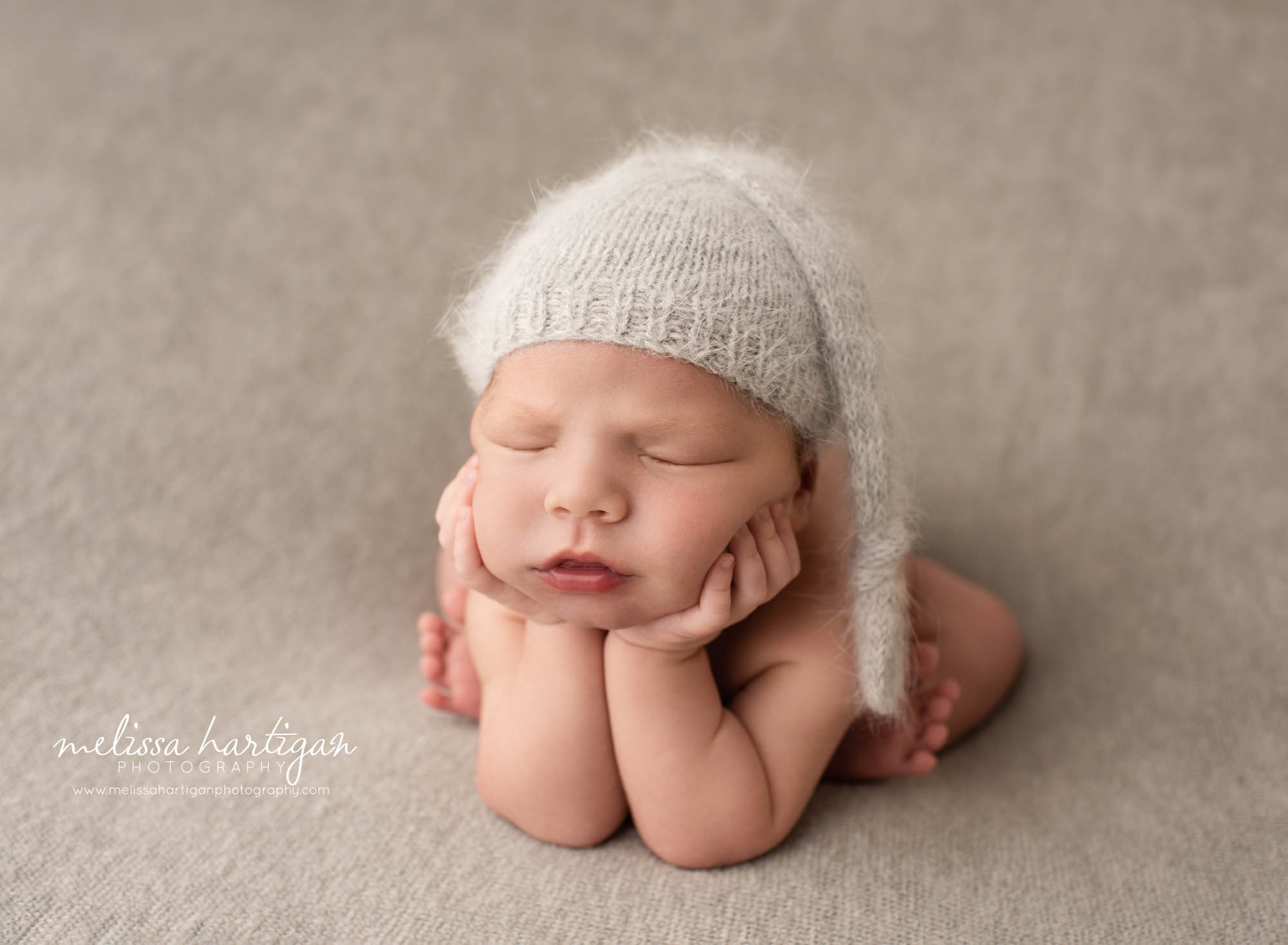newborn baby boy posed froggy pose wearing knitted sleepy cap newborn photography newington ct
