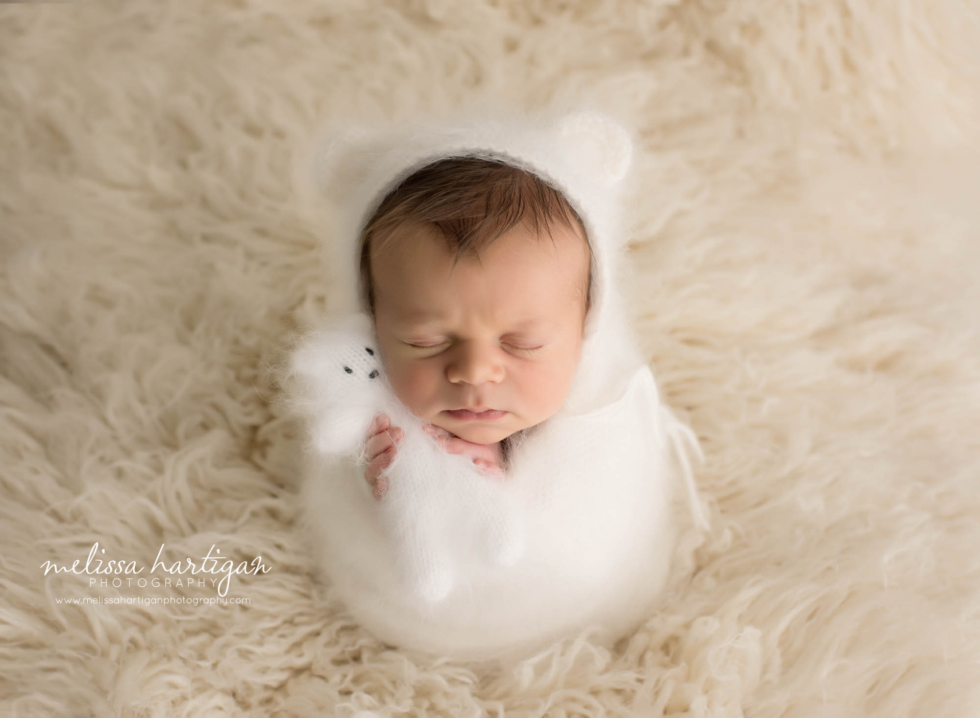 newborn baby boy wearing white cream knitted bear bonnet with matching teddy