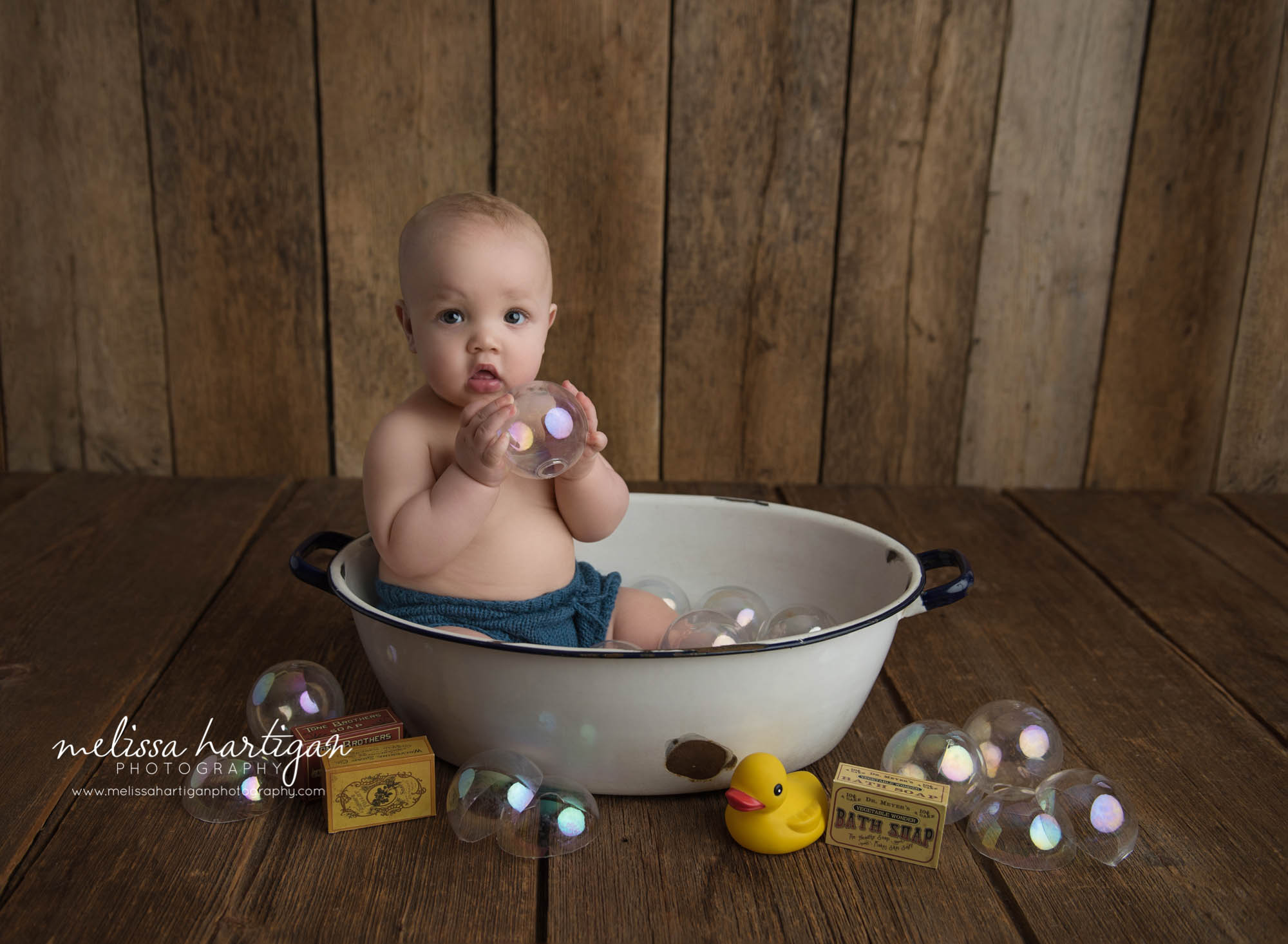 baby boy sitting in white ceramic tub with bubble props holding bubble baby photogaphy windsor ct