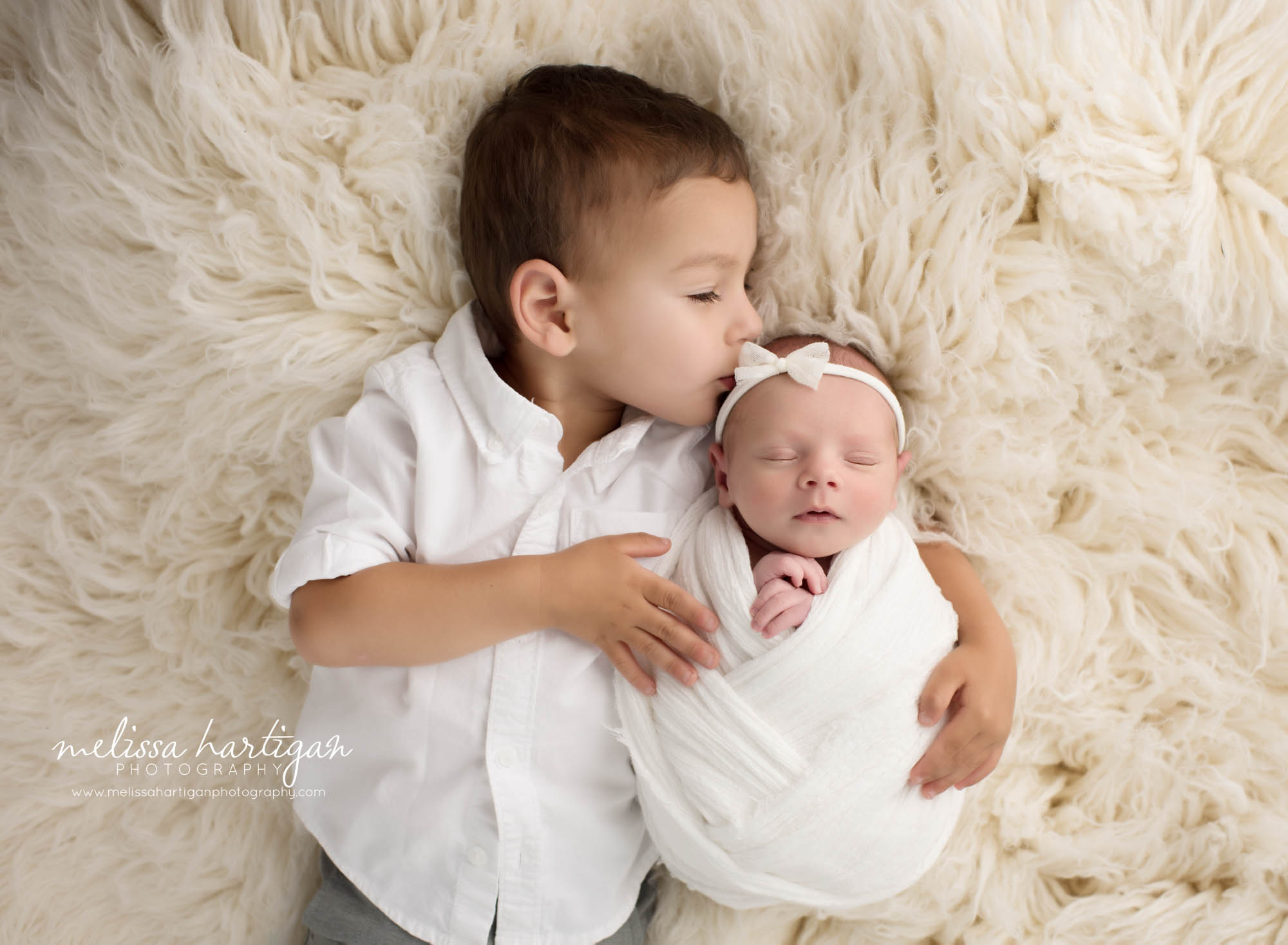 big brother giving baby sister kisses ct newborn photography
