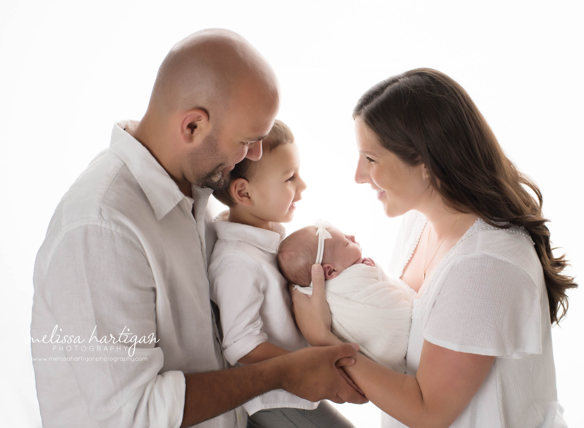 dad big brother newborn baby girl and mom standing to side for family picture