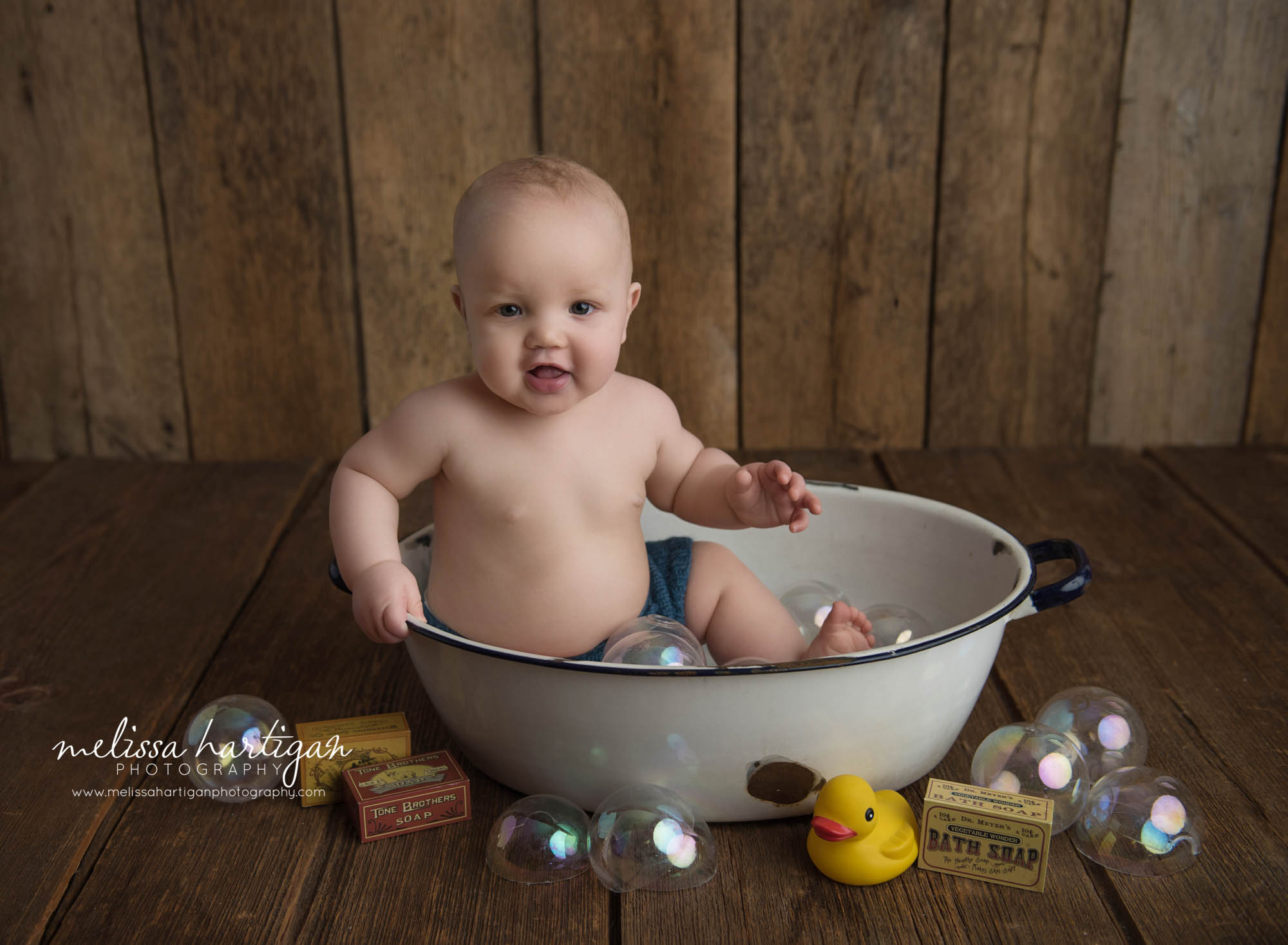 baby boy sitting in white bowl with bath bubble props 