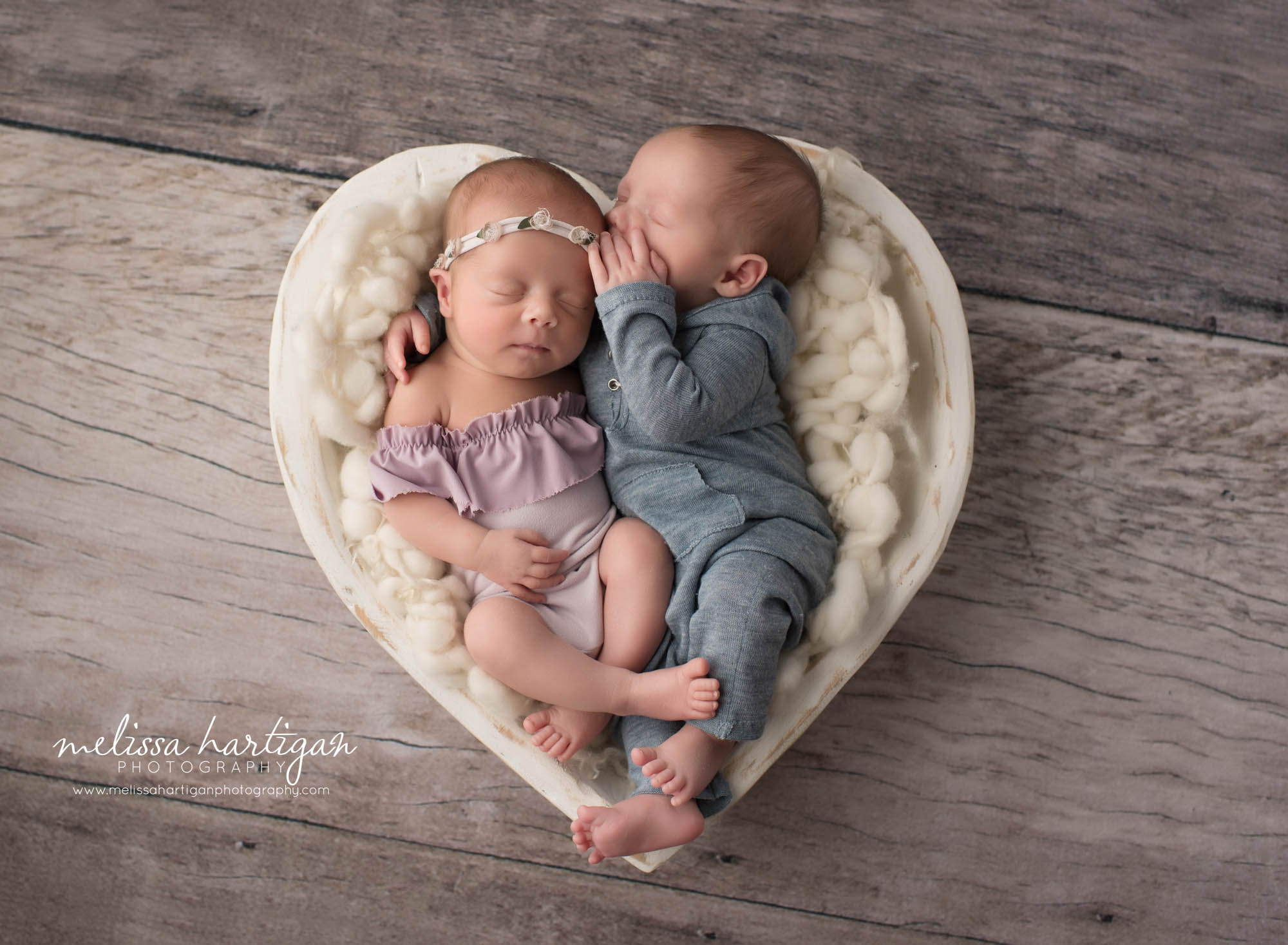 newborn boy girl twin babies posed together brother telling sister secret wearing blue and purple outfits CT Twin Newborn Photography