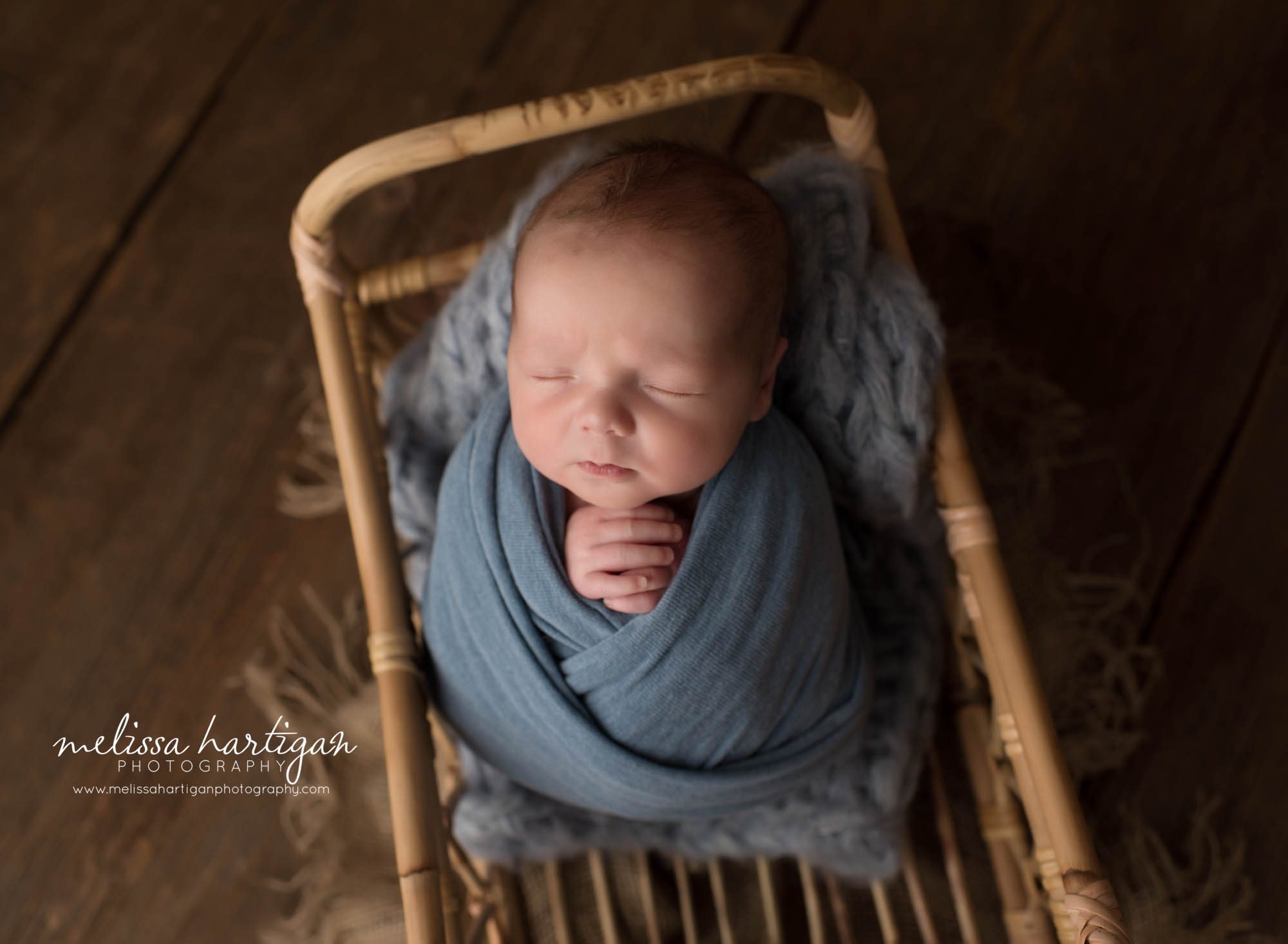 newborn baby boy wrapped blue wrap posed in basket