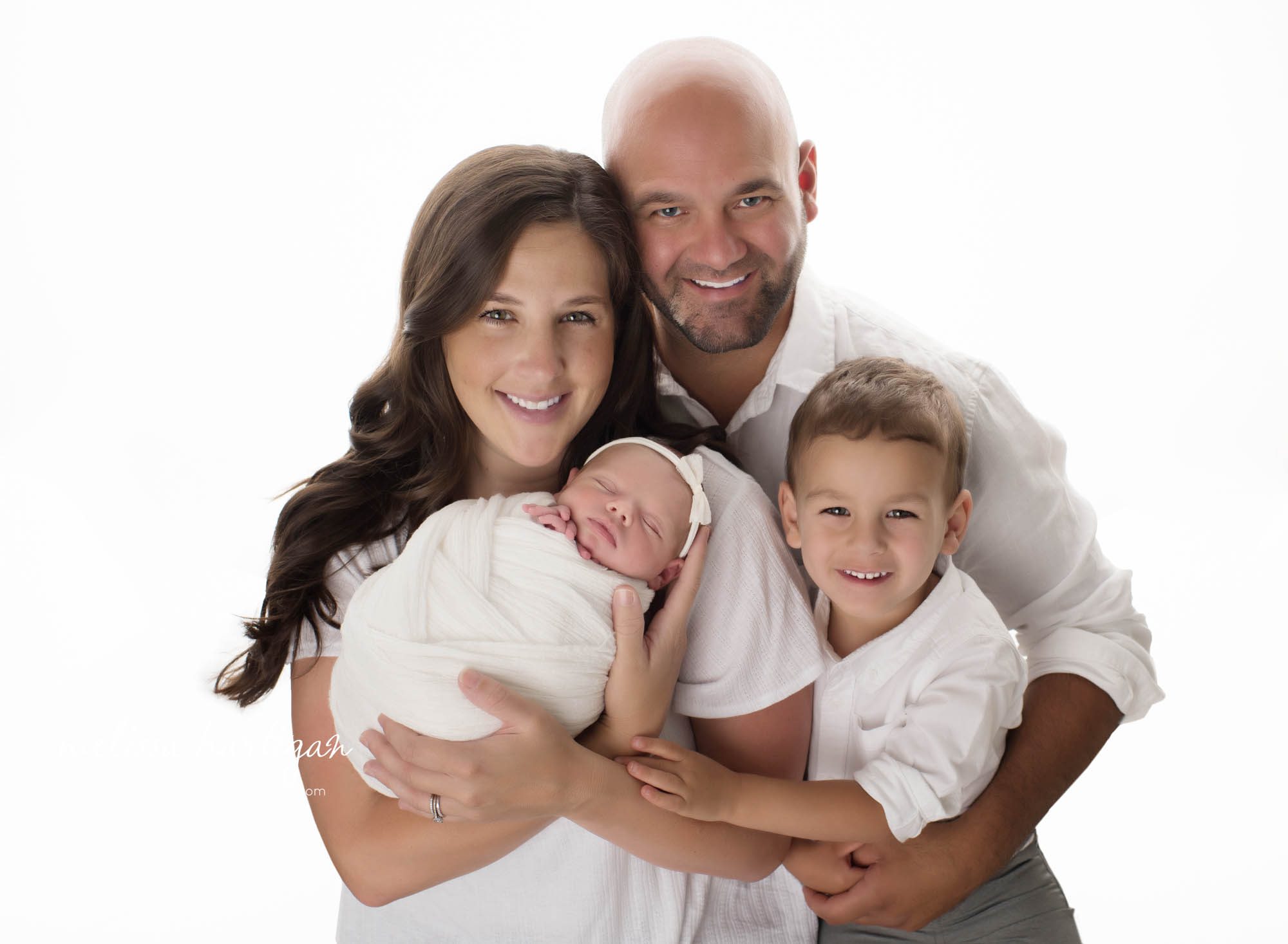 mom dad big brother and newborn girl posed together for family pose