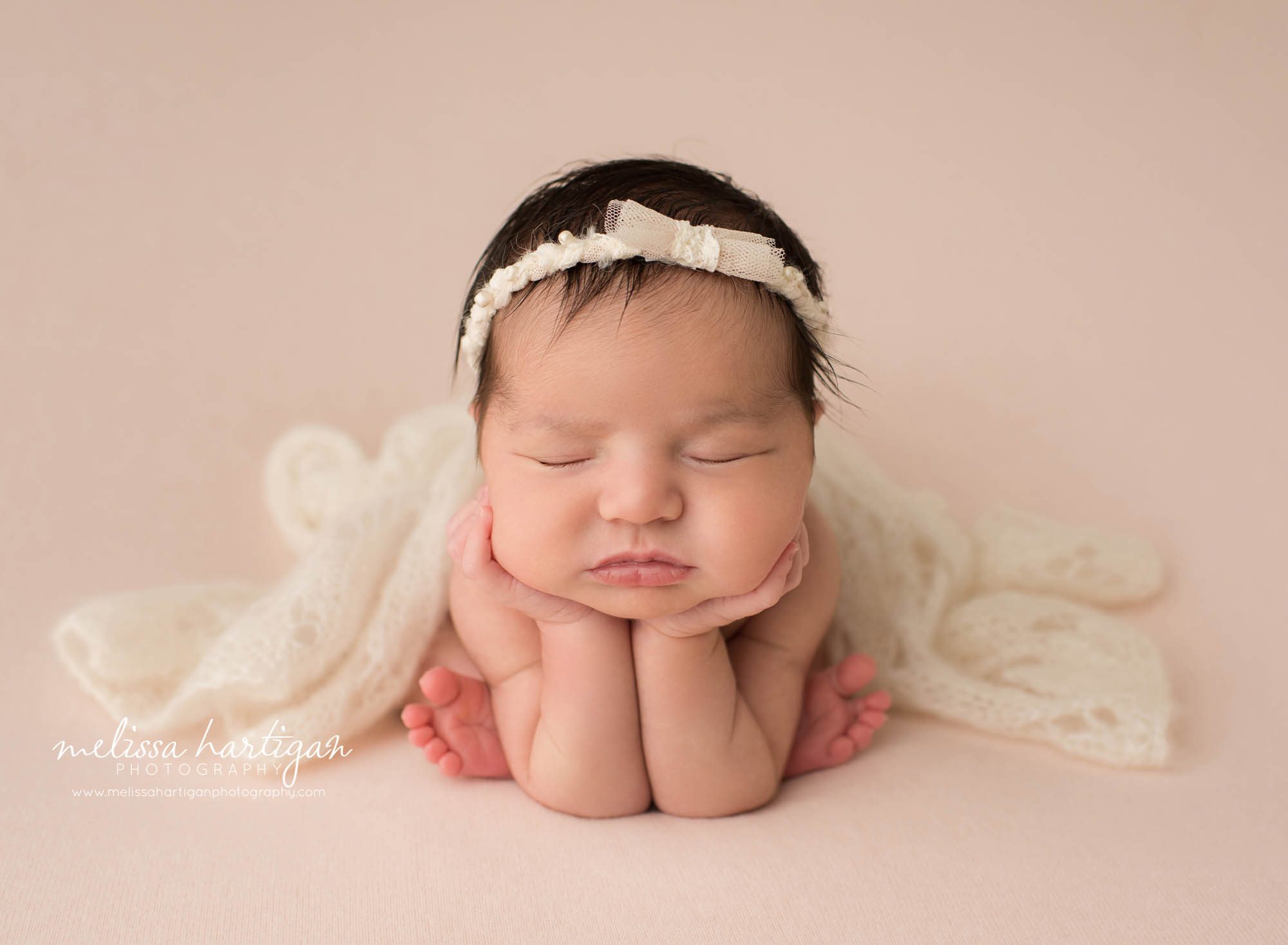 newborn baby girl posed froggy pose on pink backdrop with cream layer newborn photography Massachusetts