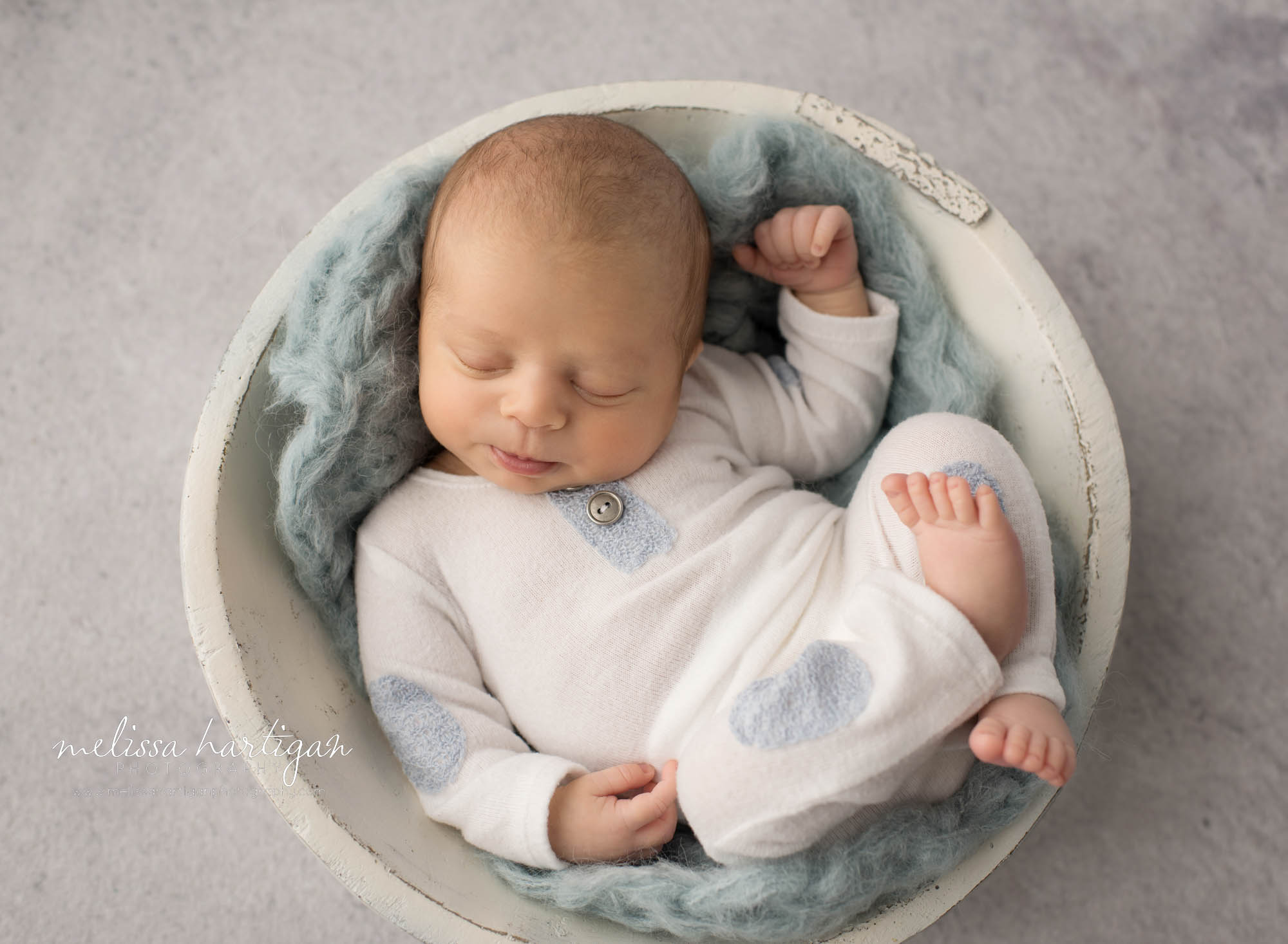 newborn baby boy posed in cream wooden bowl wearing white and blue newborn boy outfit ct newborn photorgaphy