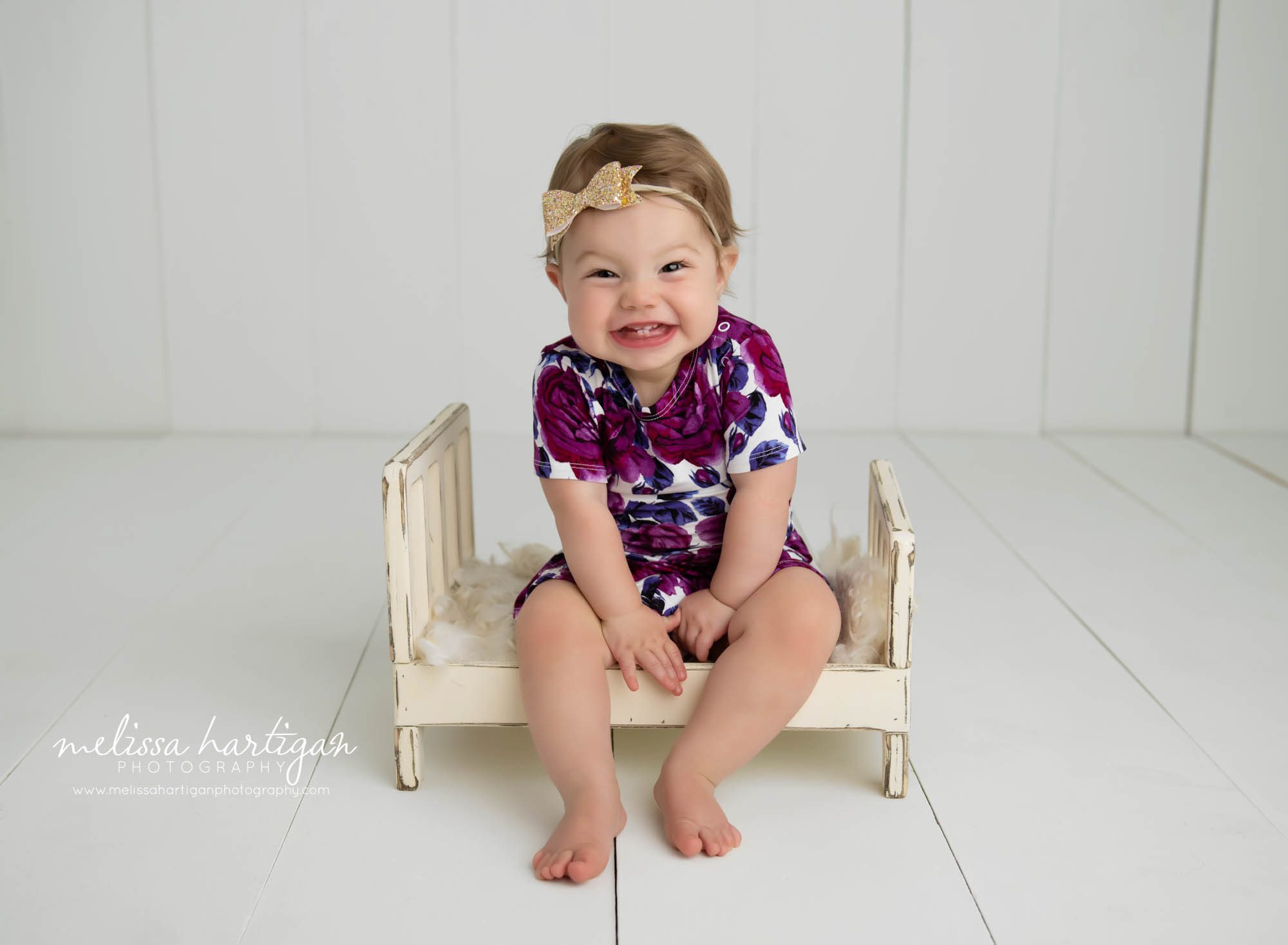 Baby girl sitting on cream wooden bed prop happy CT baby photography