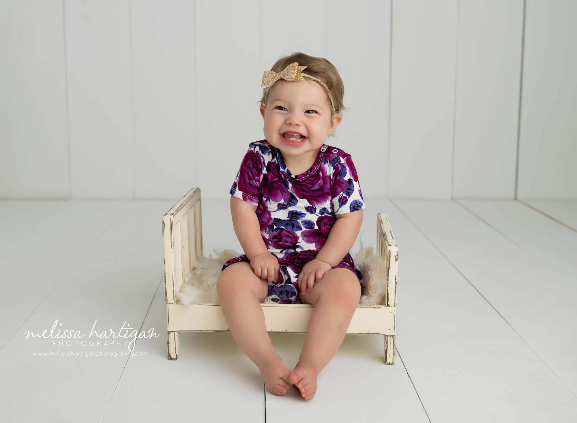 Baby girl sitting on cream wooden bed prop happy baby photography Connecticut