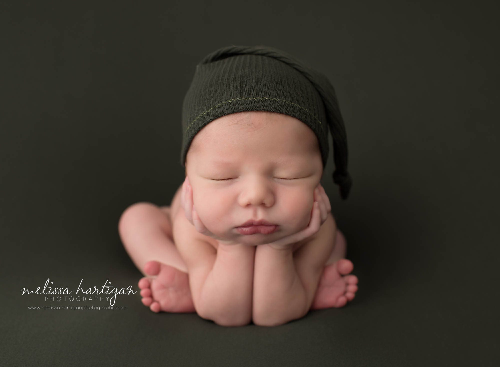 baby boy posed froggy pose wearing green sleepy cap