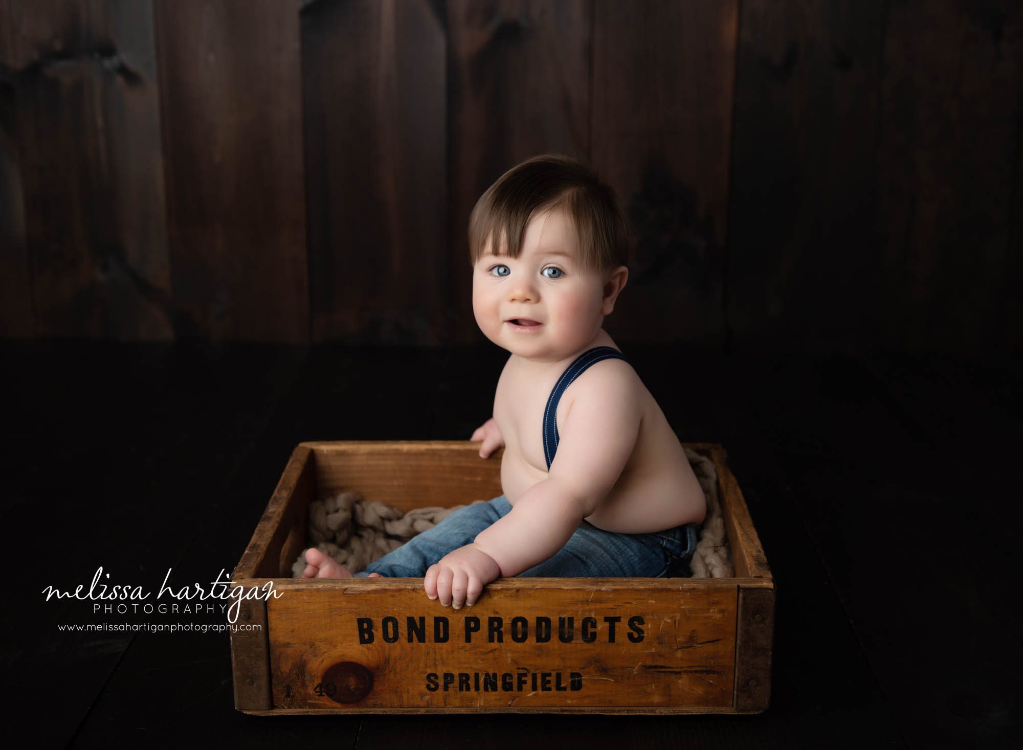 baby boy sitting in wooden crate in baby milestone CT Photography