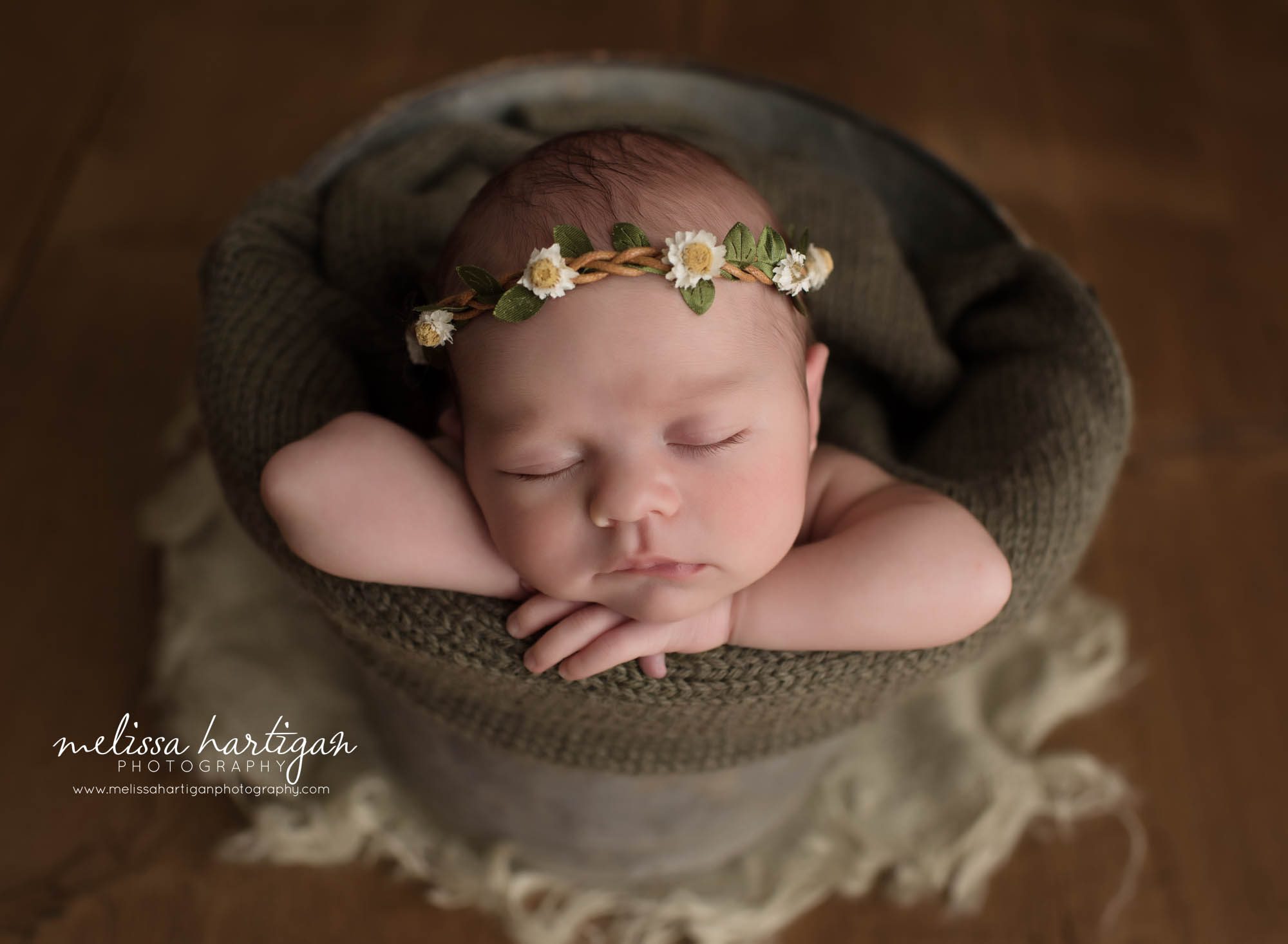 newborn baby girl posed on bucket with olive green knitted wrap and flower headband crown CT newborn photographer