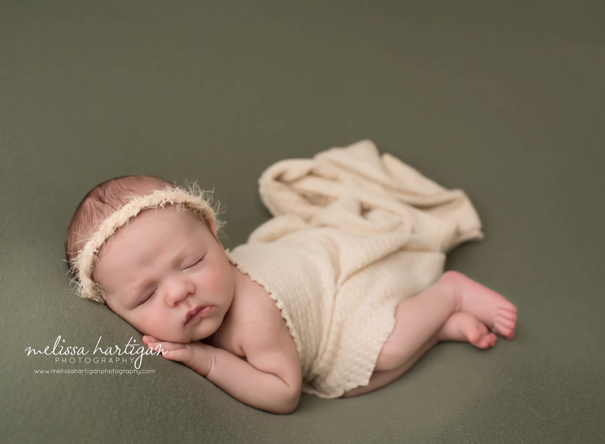 newborn baby girl posed on side with hand under cheek sleeping