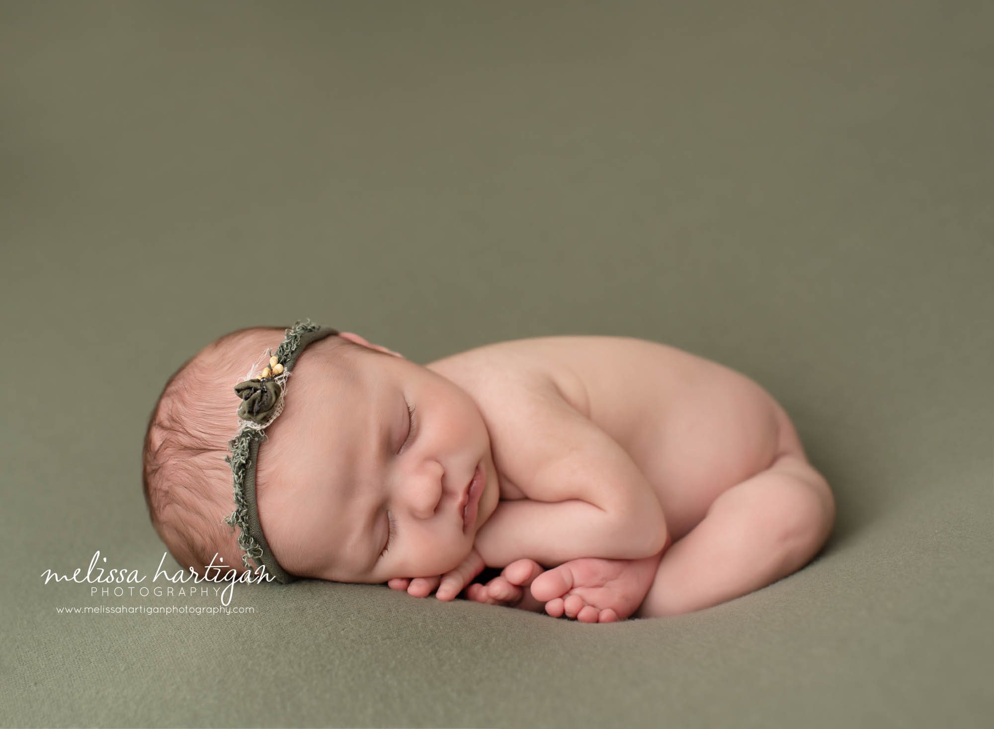 newborn baby girl posed in taco pose wearing green headband colchester CT newborn photography