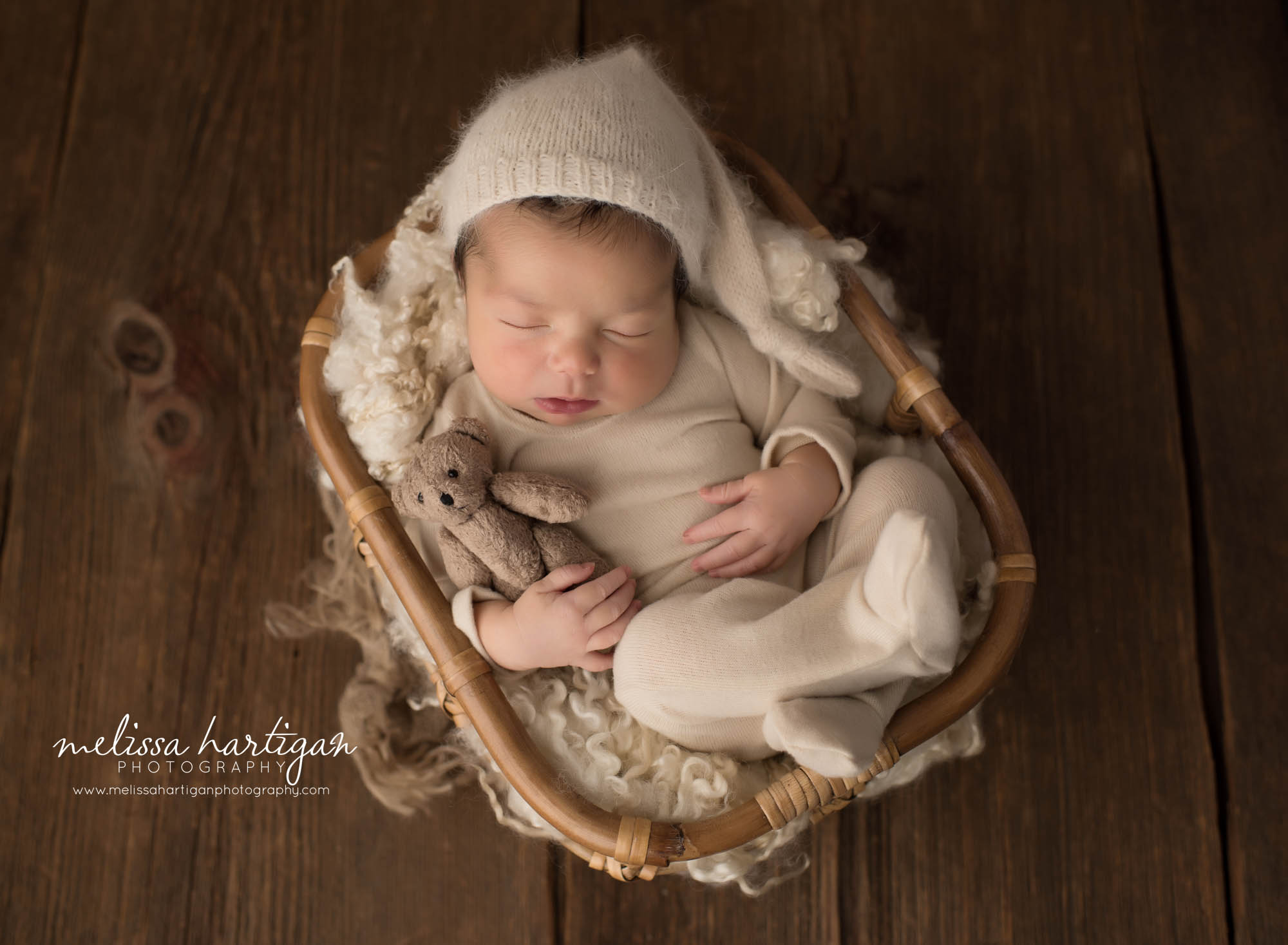 newborn baby boy wearing foot romper with knitted sleepy cap holding teddy newborn photography south windsor