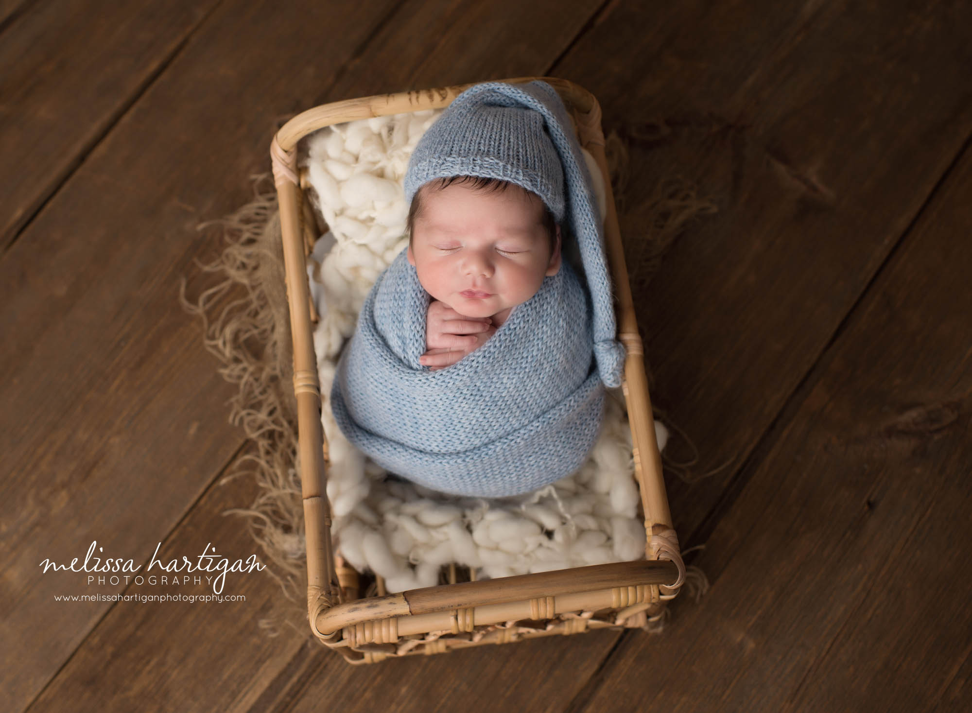 Newborn baby boy wrapped in baby blue knitted wrap wearing sleepy cap Meriden CT newborn photography