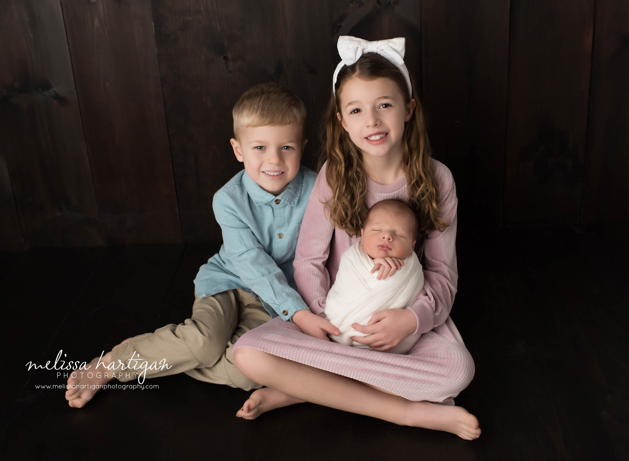 Newborn baby brother posed with older siblings newborn photoshoot CT