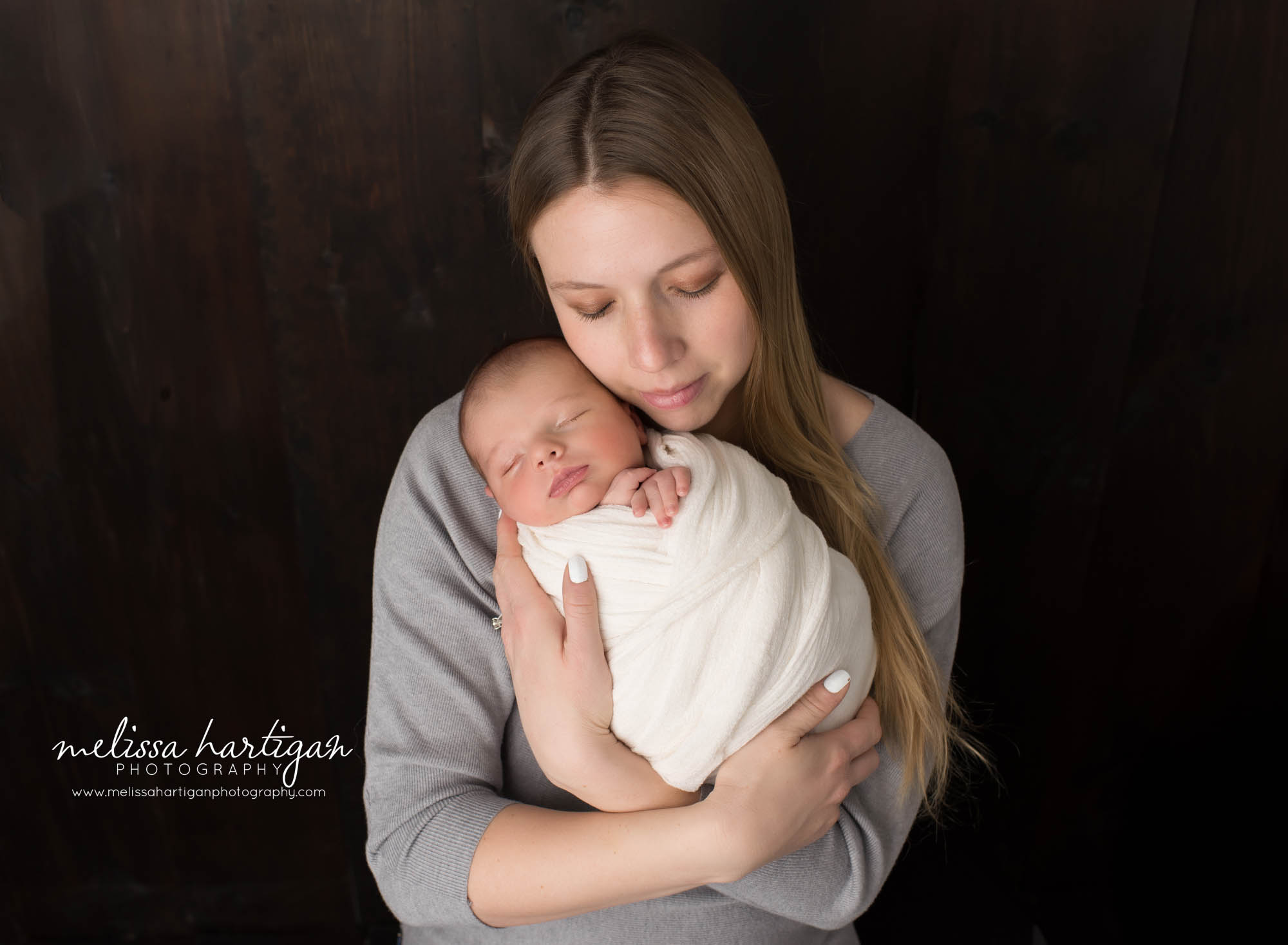 mom holding newborn son in parents pose