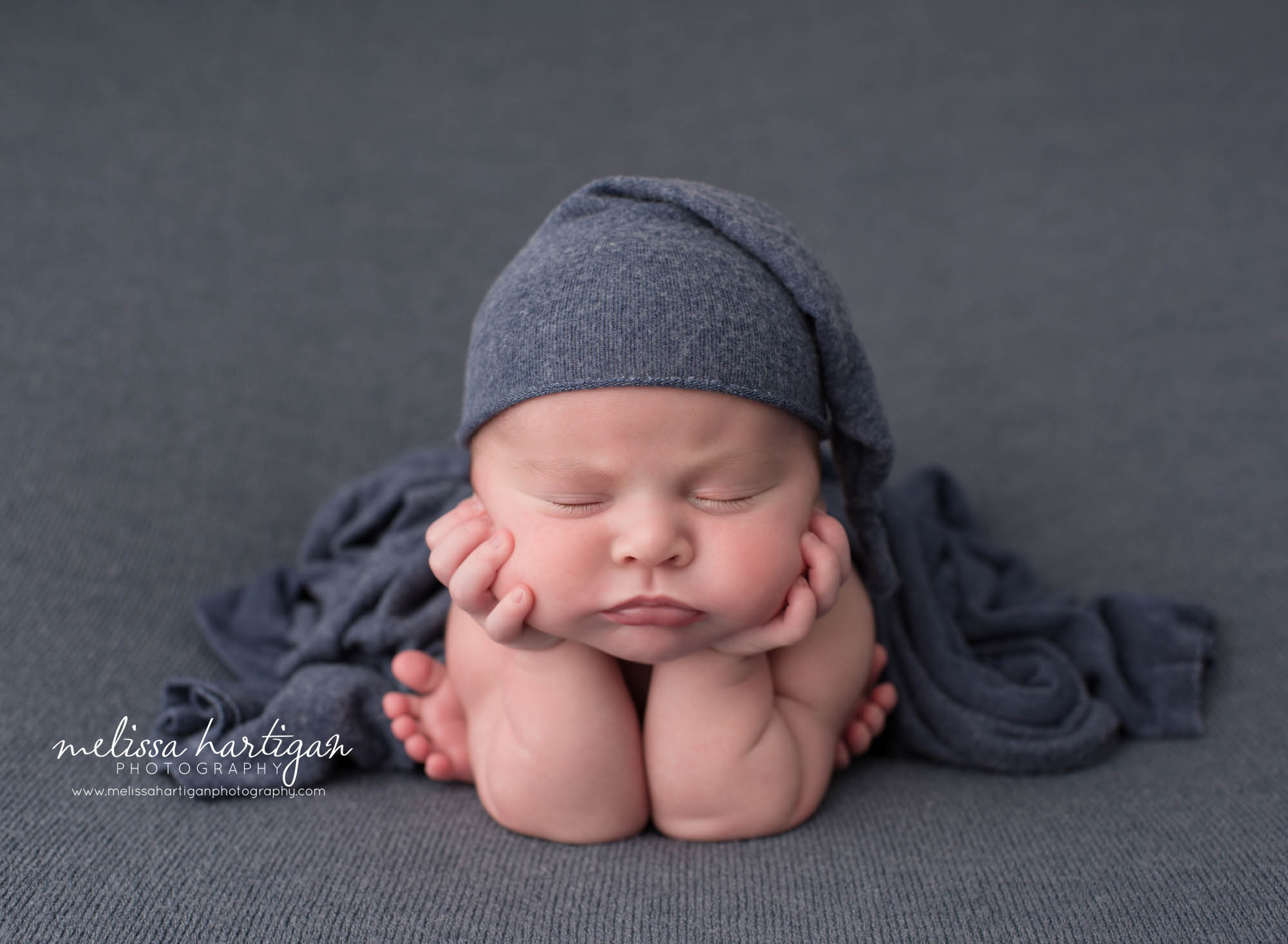 newborn baby boy posed froggy pose wearing blue sleepy cap CT newborn photography wallingford