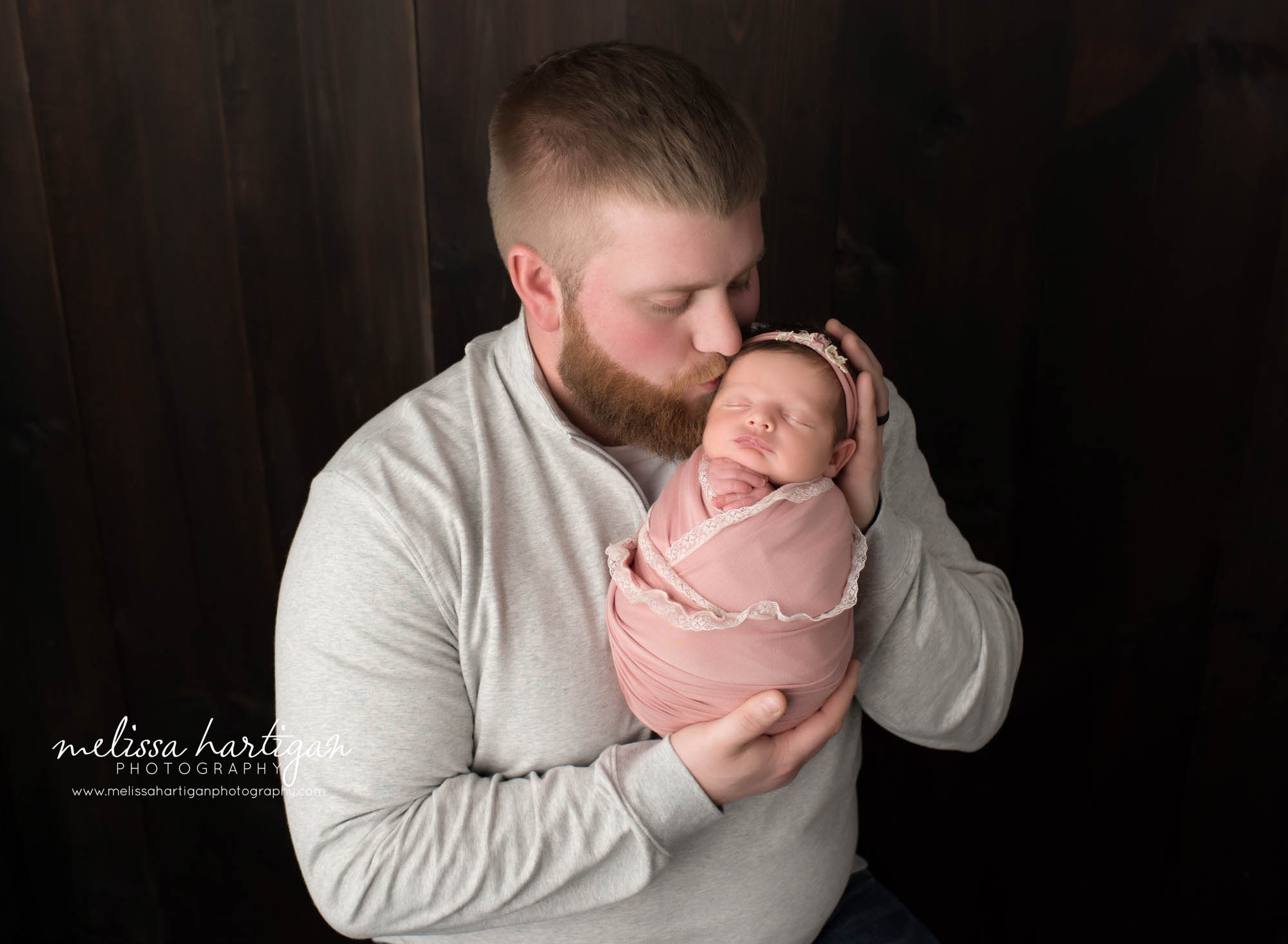 dad holding newborn daughter in parent pose
