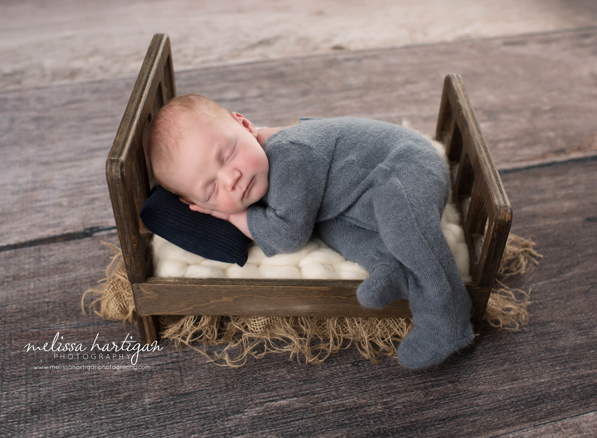 newborn baby boy posed on wooden bed prop newborn photography hebron