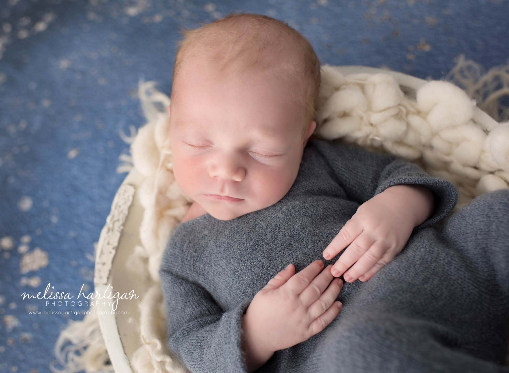 newborn baby boy posed in cream wooden bowl wearing blue newborn outfit newborn photography hebron CT