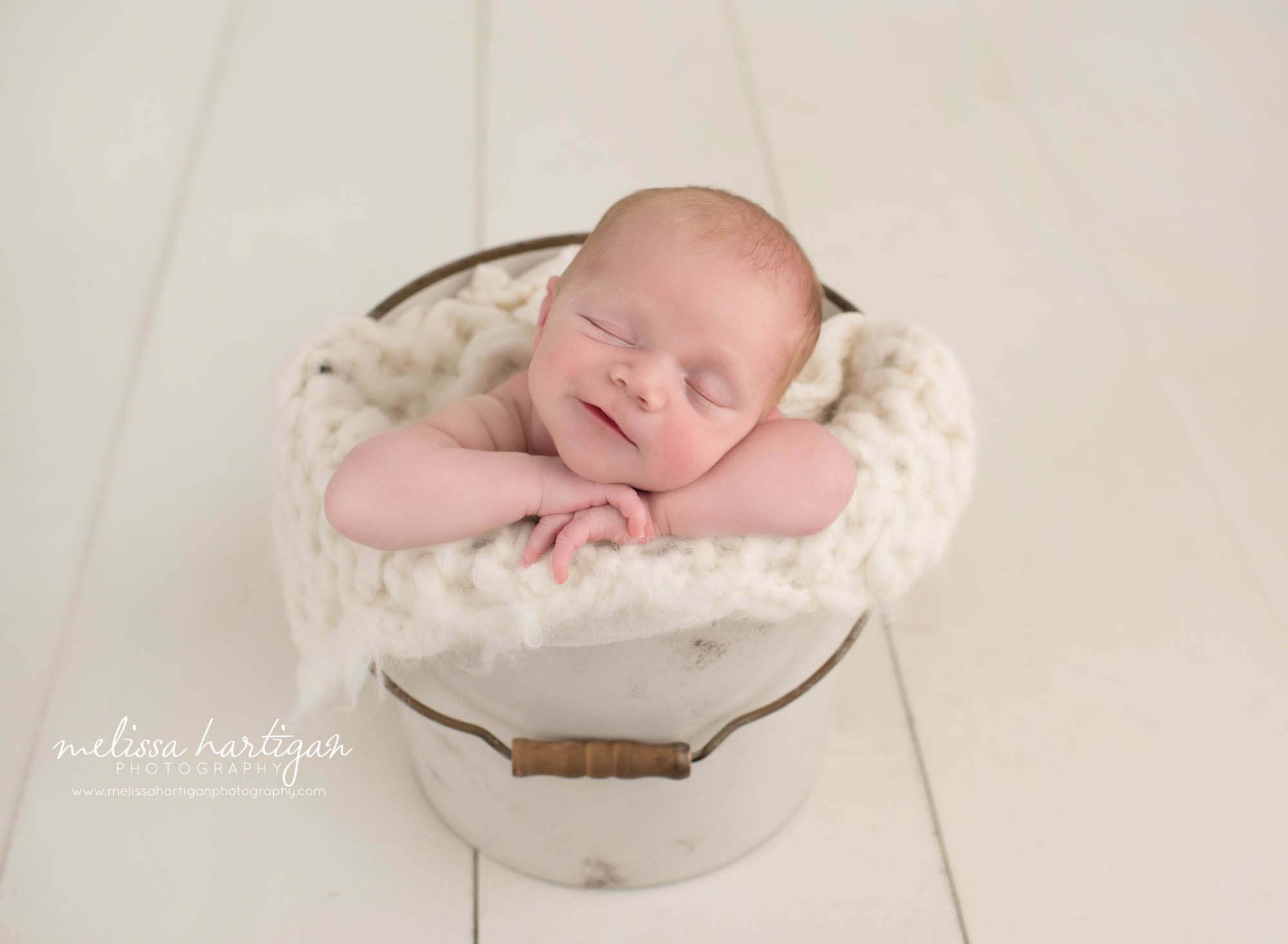 newborn baby boy posed in cream bucket smiling sleeping newborn photography hebron CT