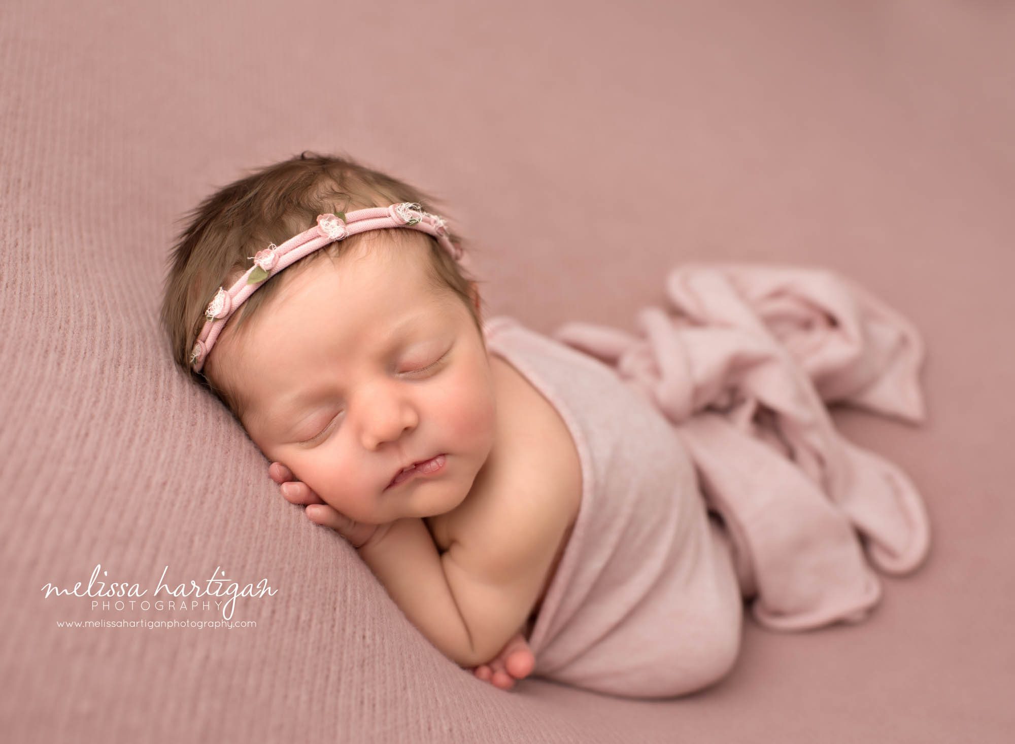 newborn baby girl posed in modified taco pose with pink layer wrap wearing pink flower headband Niantic CT Newborn photography