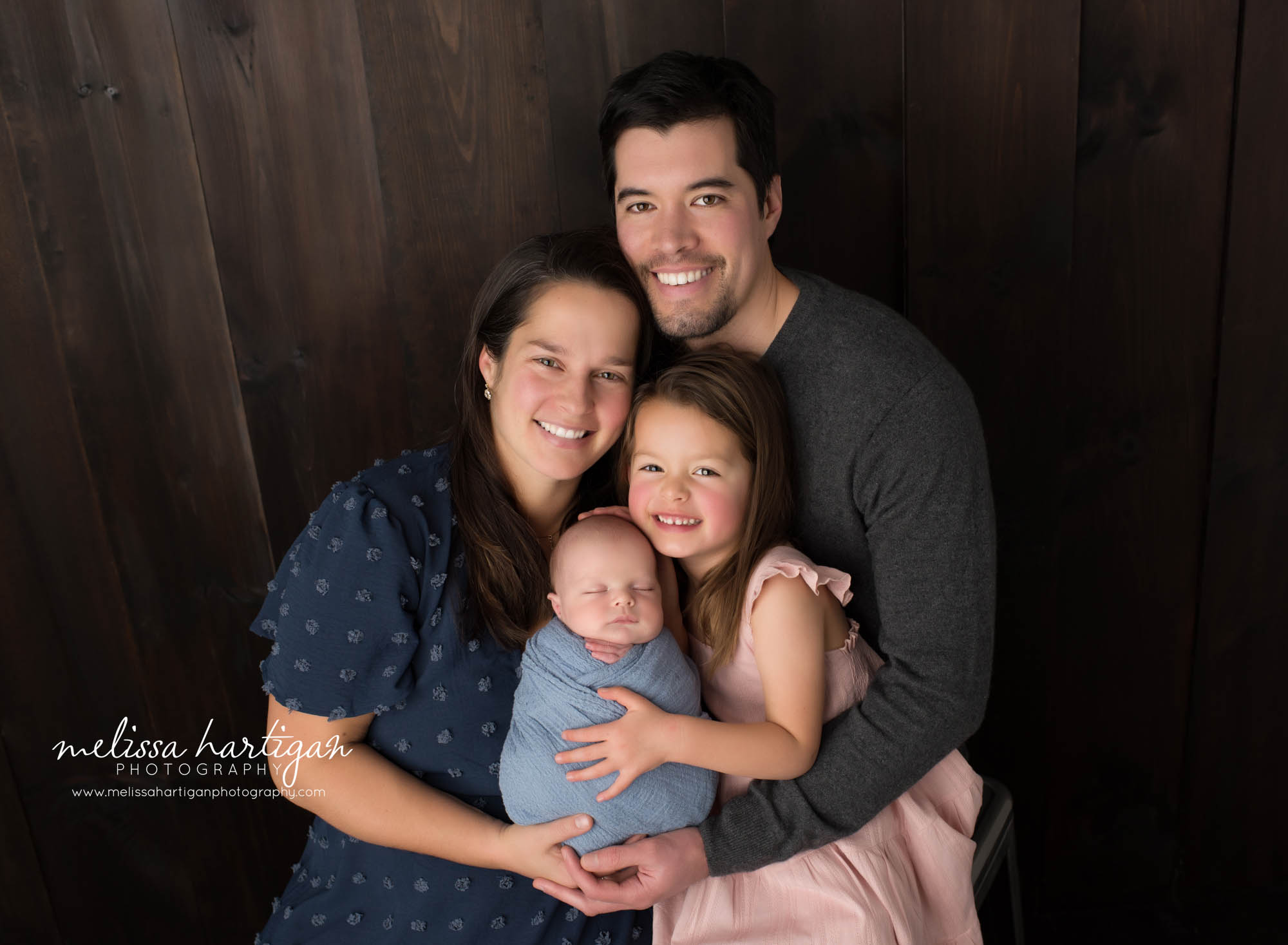 mom dad big sister and newborn baby boy posed together for family pose newborn photoshoot