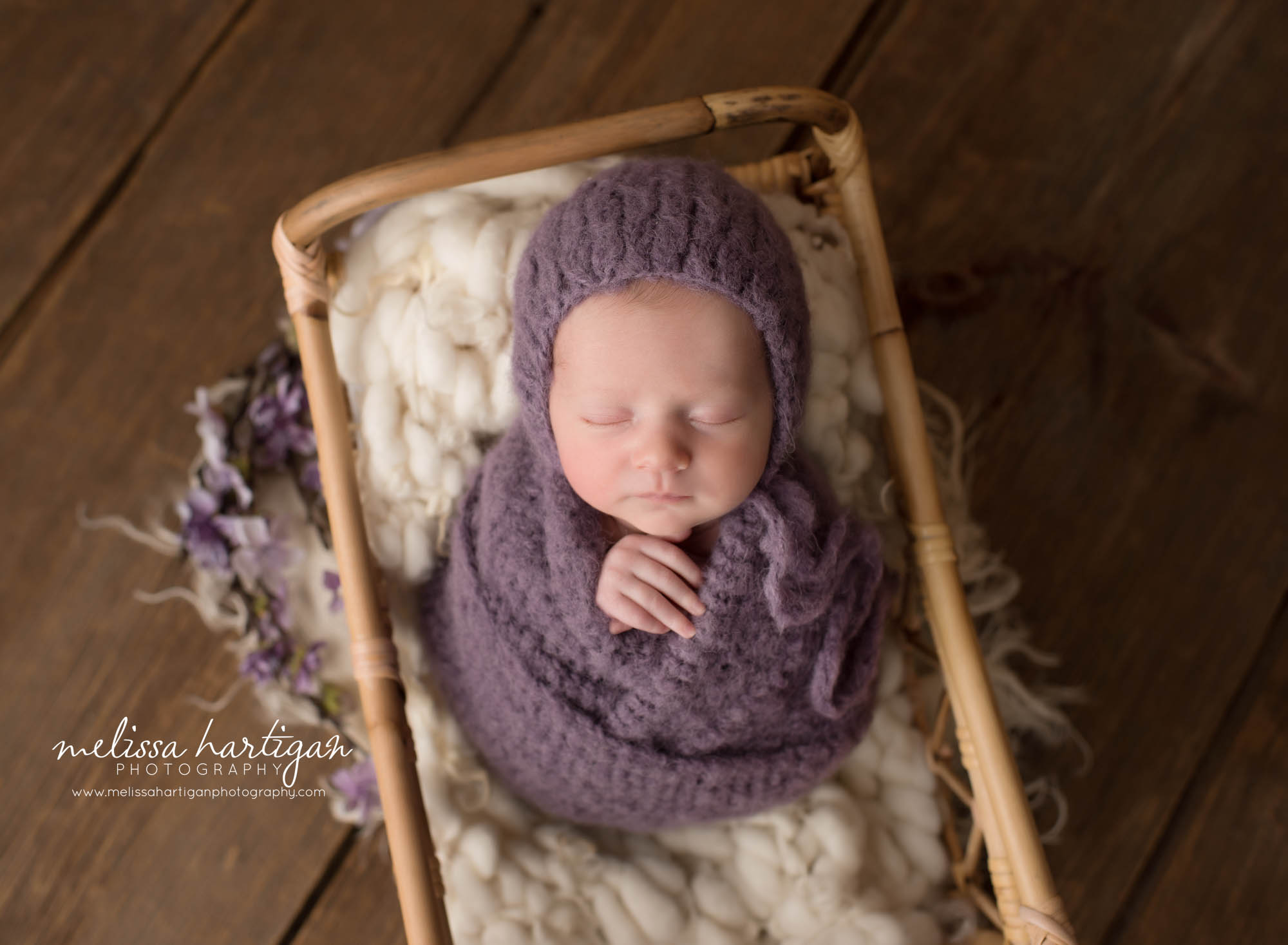 newborn baby girl posed in basket swaddled in purple knit wrap and bonnet CT maternity baby photography