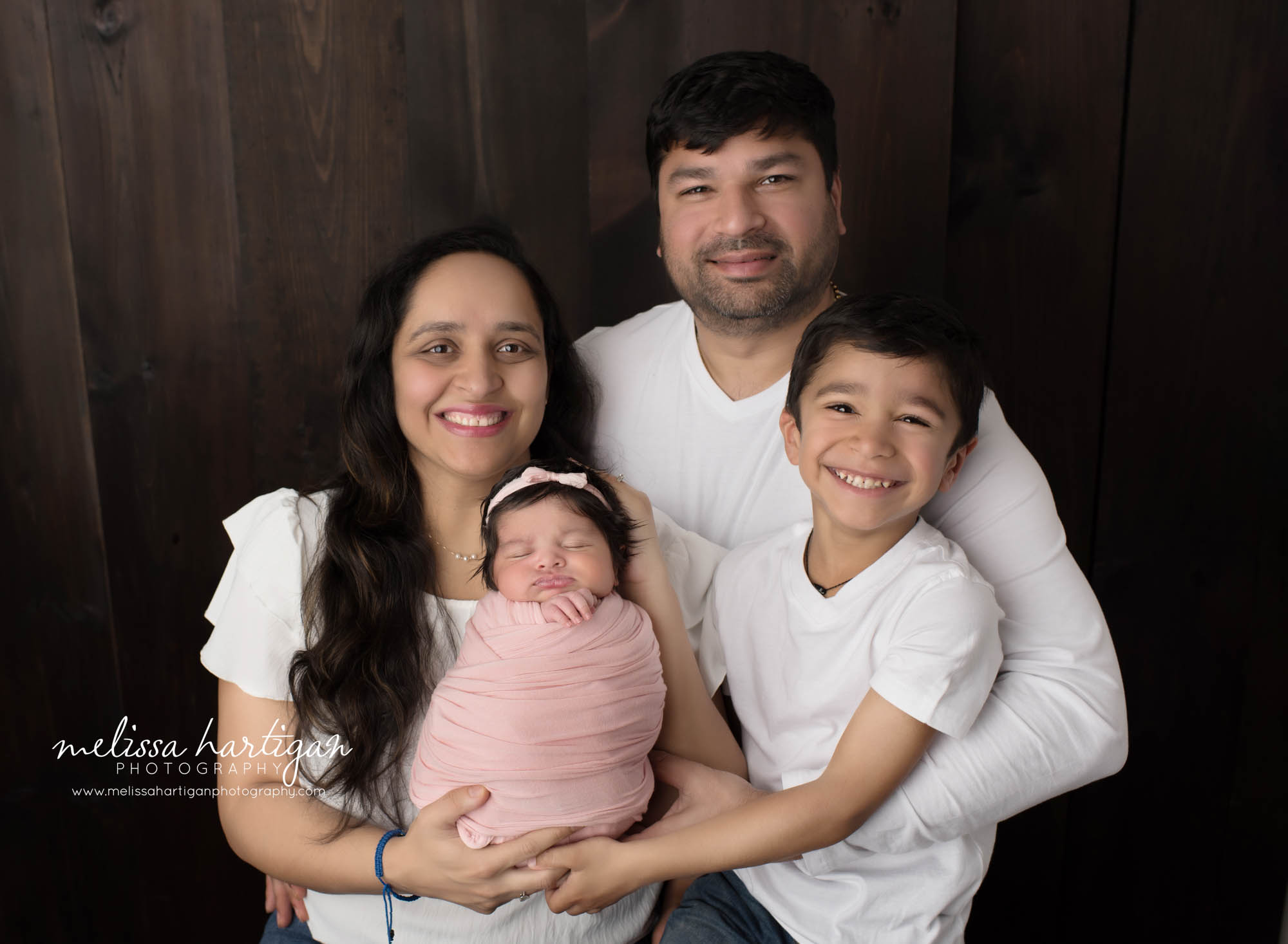 mom dad big brother and newborn baby girl posed together in newborn photoshoot Suffield CT Newborn photography