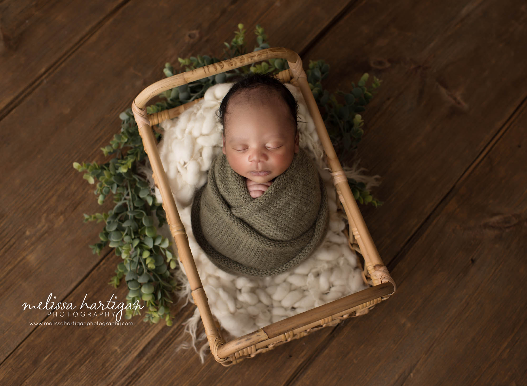 Newborn baby boy wrapped in green wrap posed in basket Tolland Newborn Photography