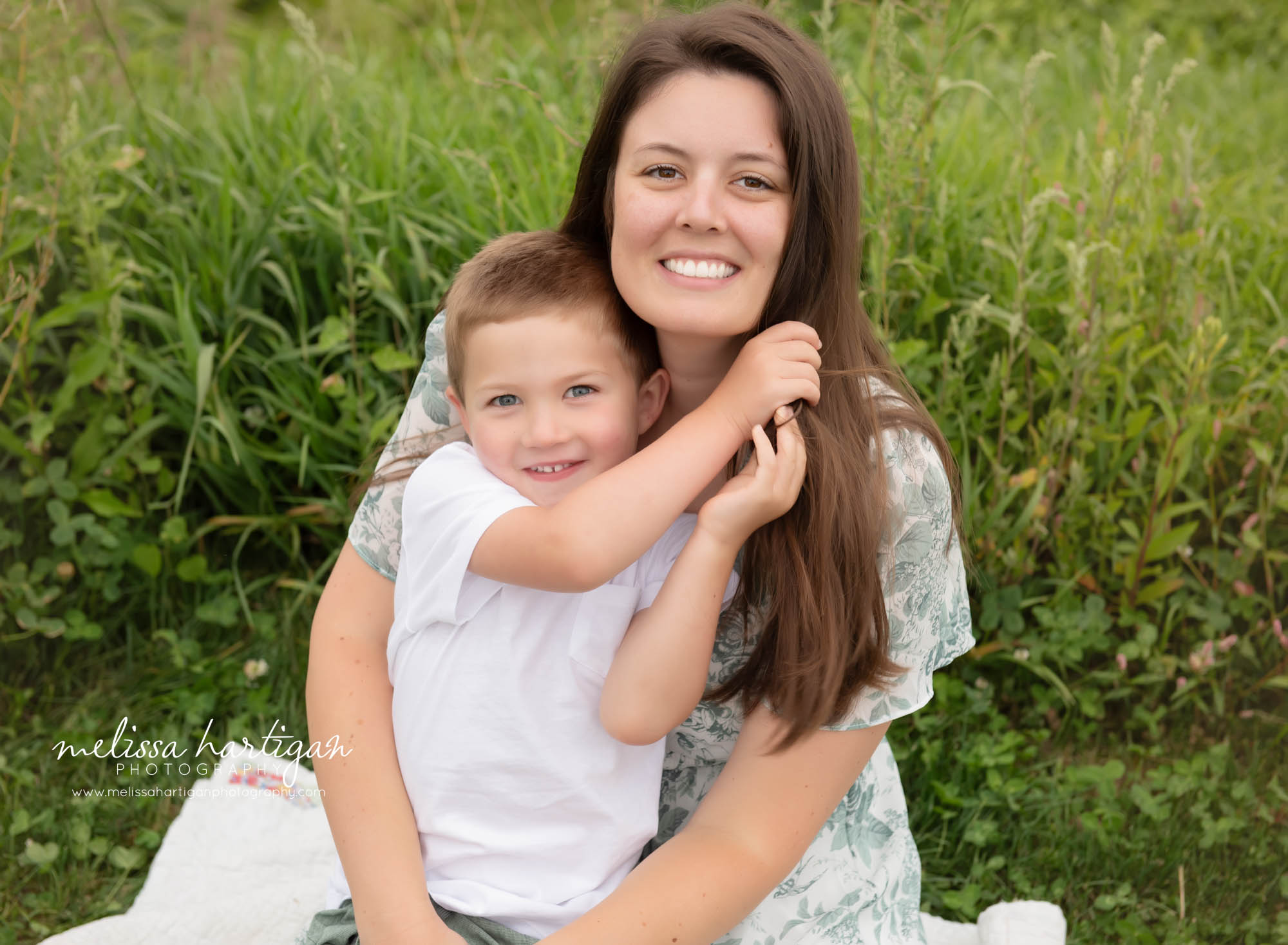Mom sitting with son in grass happy smiling Ellington CT Family Photography