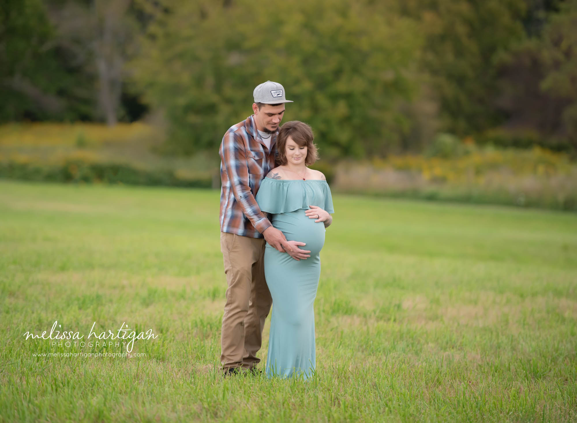 Expectant couple standing together holding baby bump