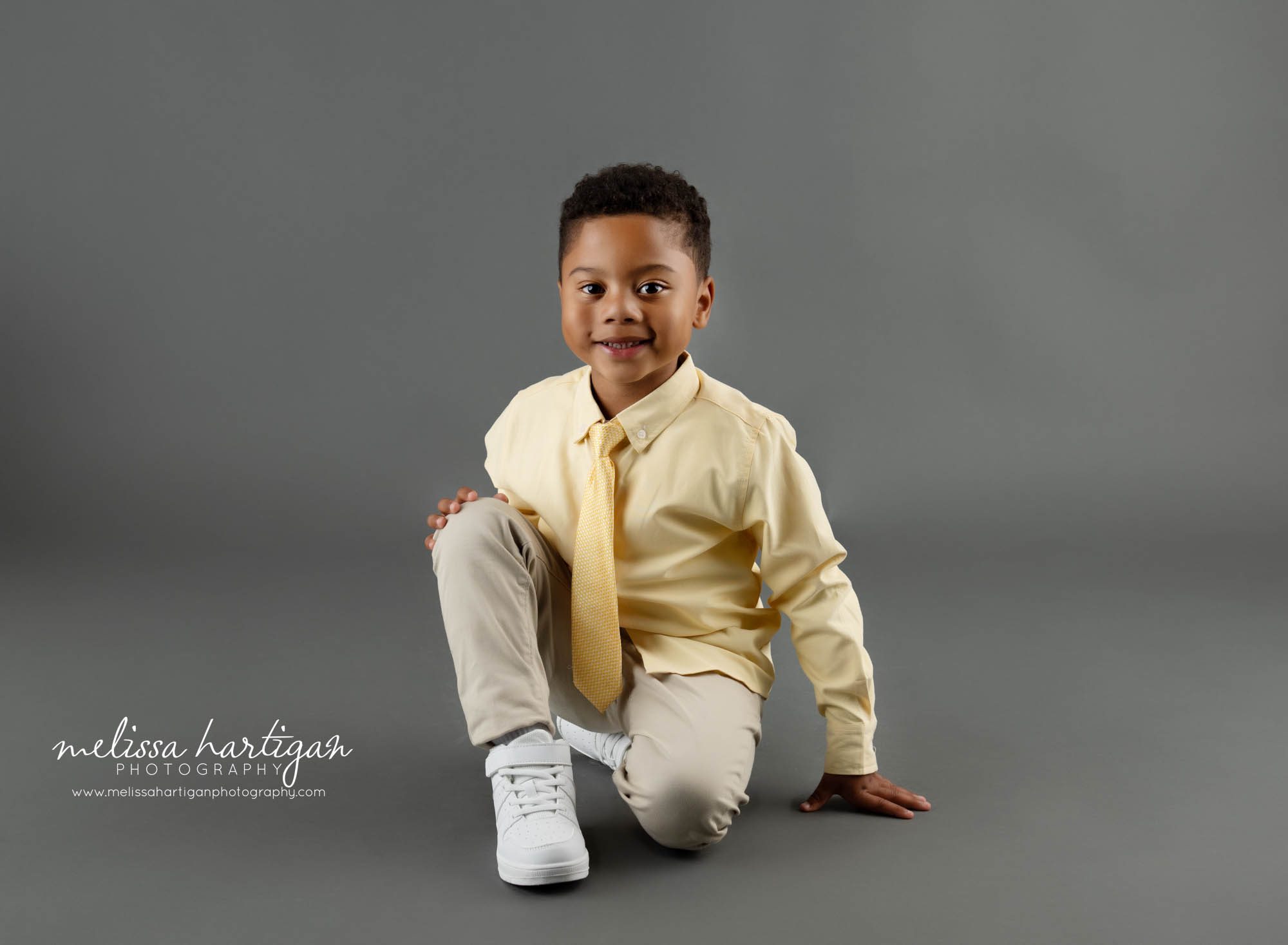 Boy sitting kneeling down on floor North Haven Sibling Photography