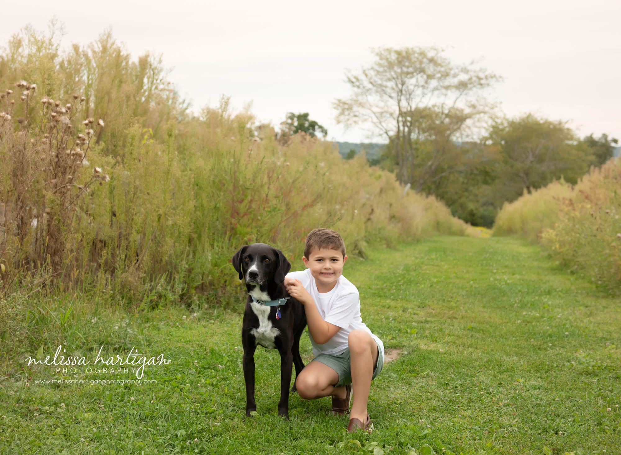 Boy kneeling down with family dog Ellington CT Family Photography