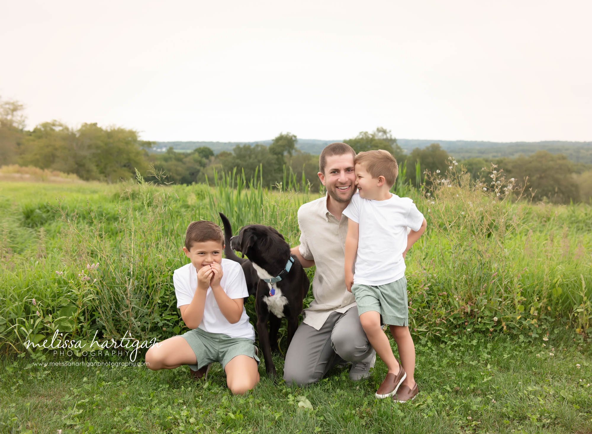 Dad sitting with two sons and family dog for unposed family photography Ellington CT Family Photography