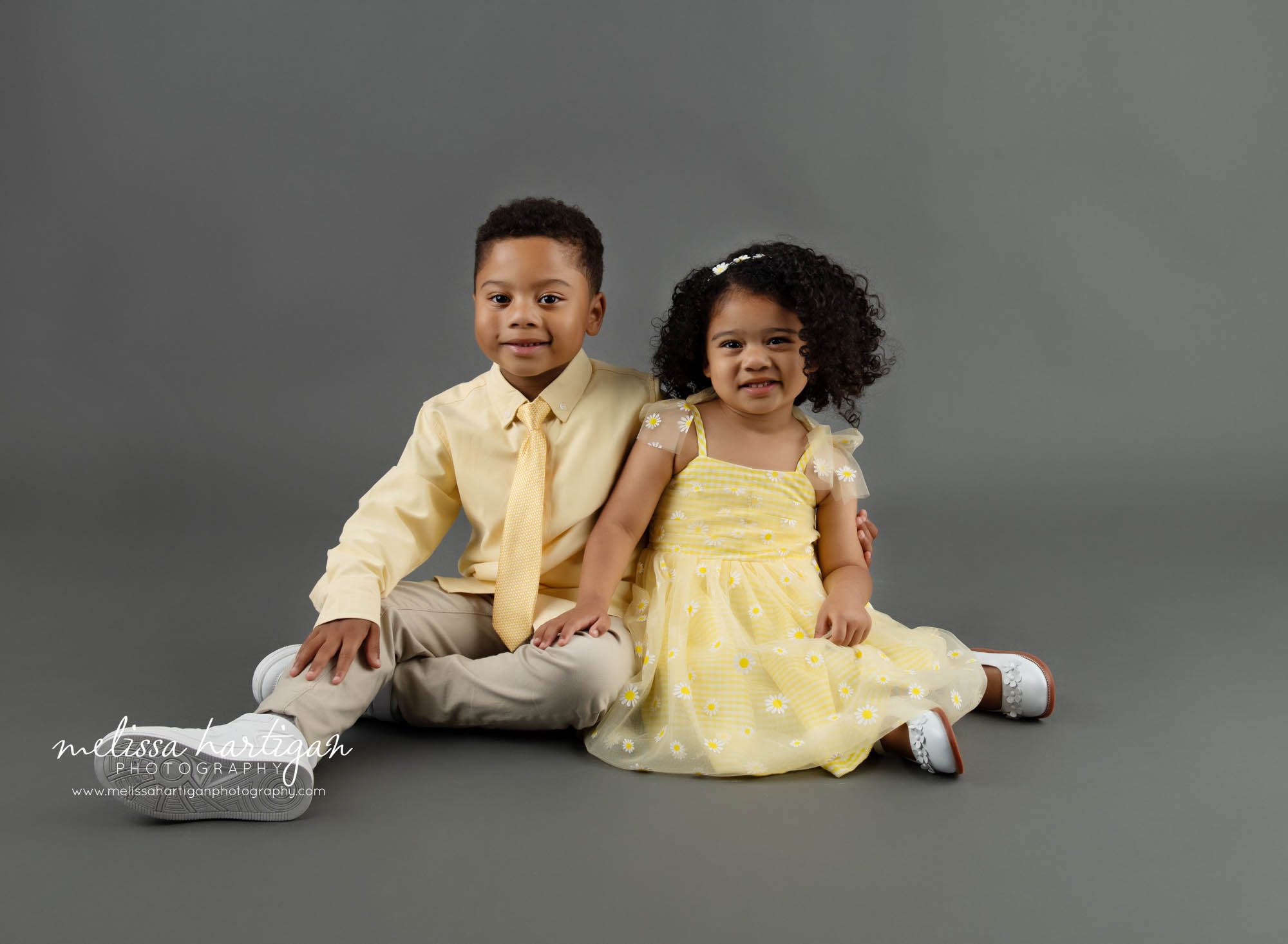 Brother and sister sitting together for portraits milestone sibling photography