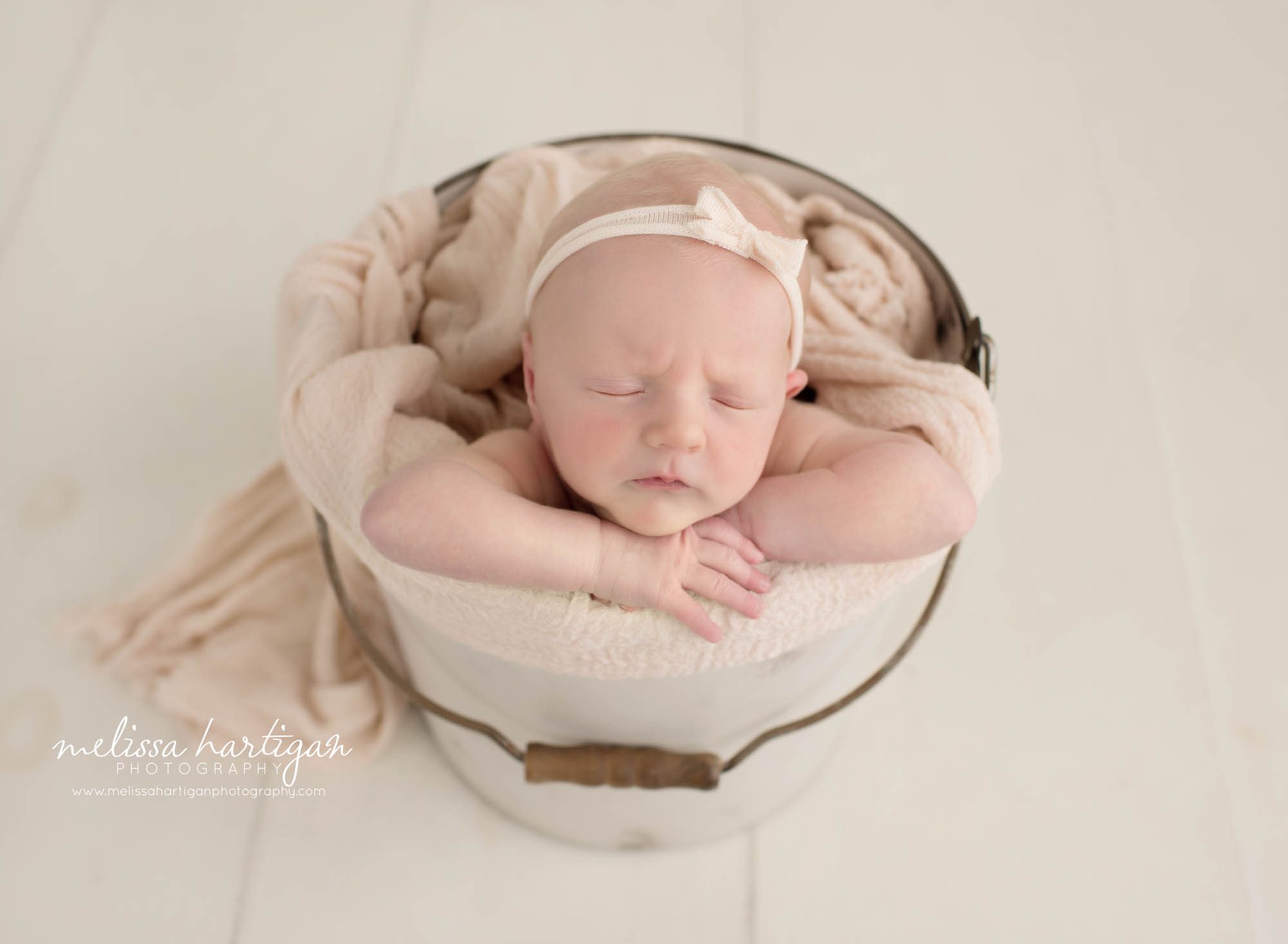 newborn baby girl posed in bucket sleeping Stafford Springs Baby Photography