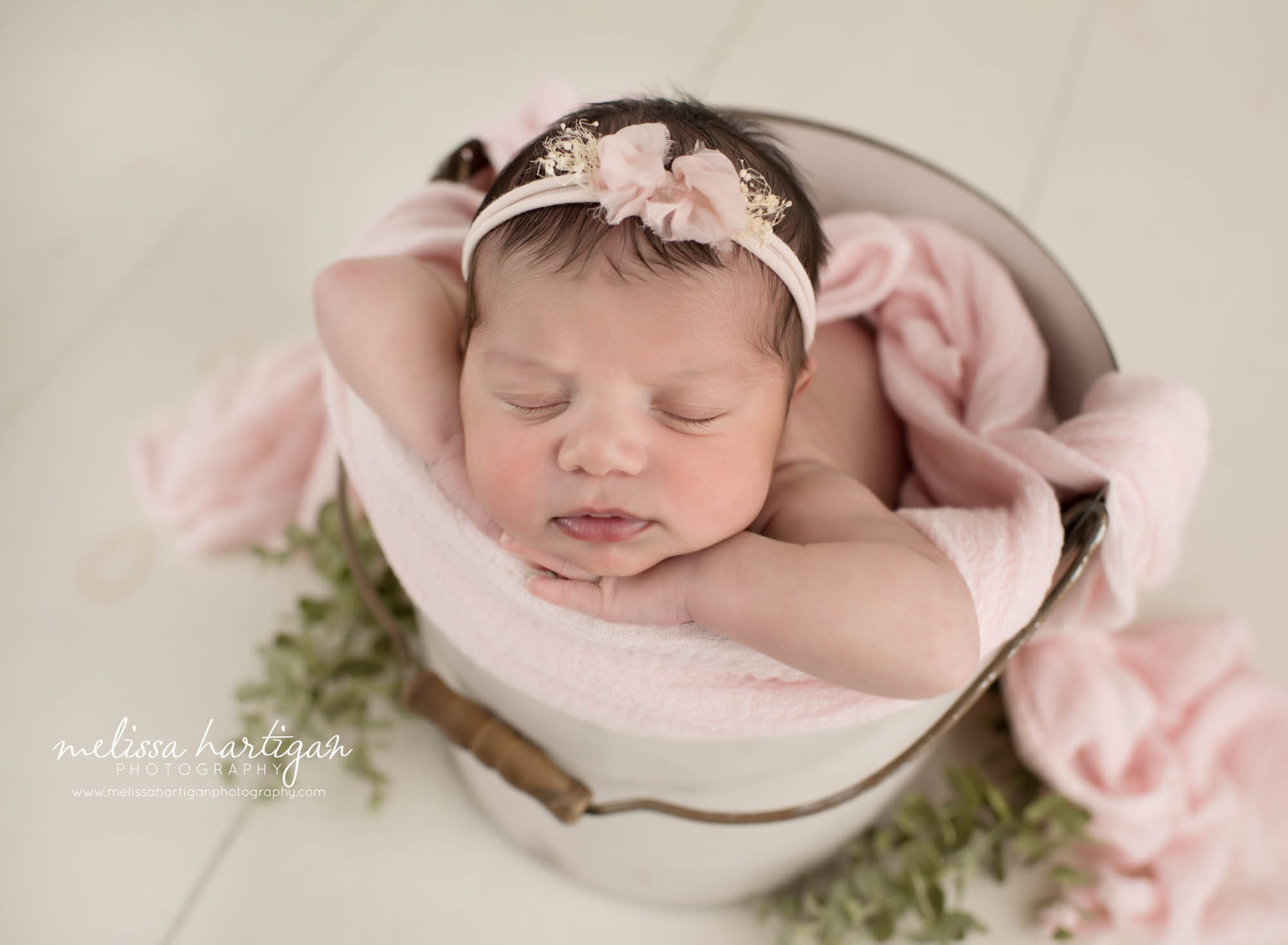 Newborn baby girl posed in bucket