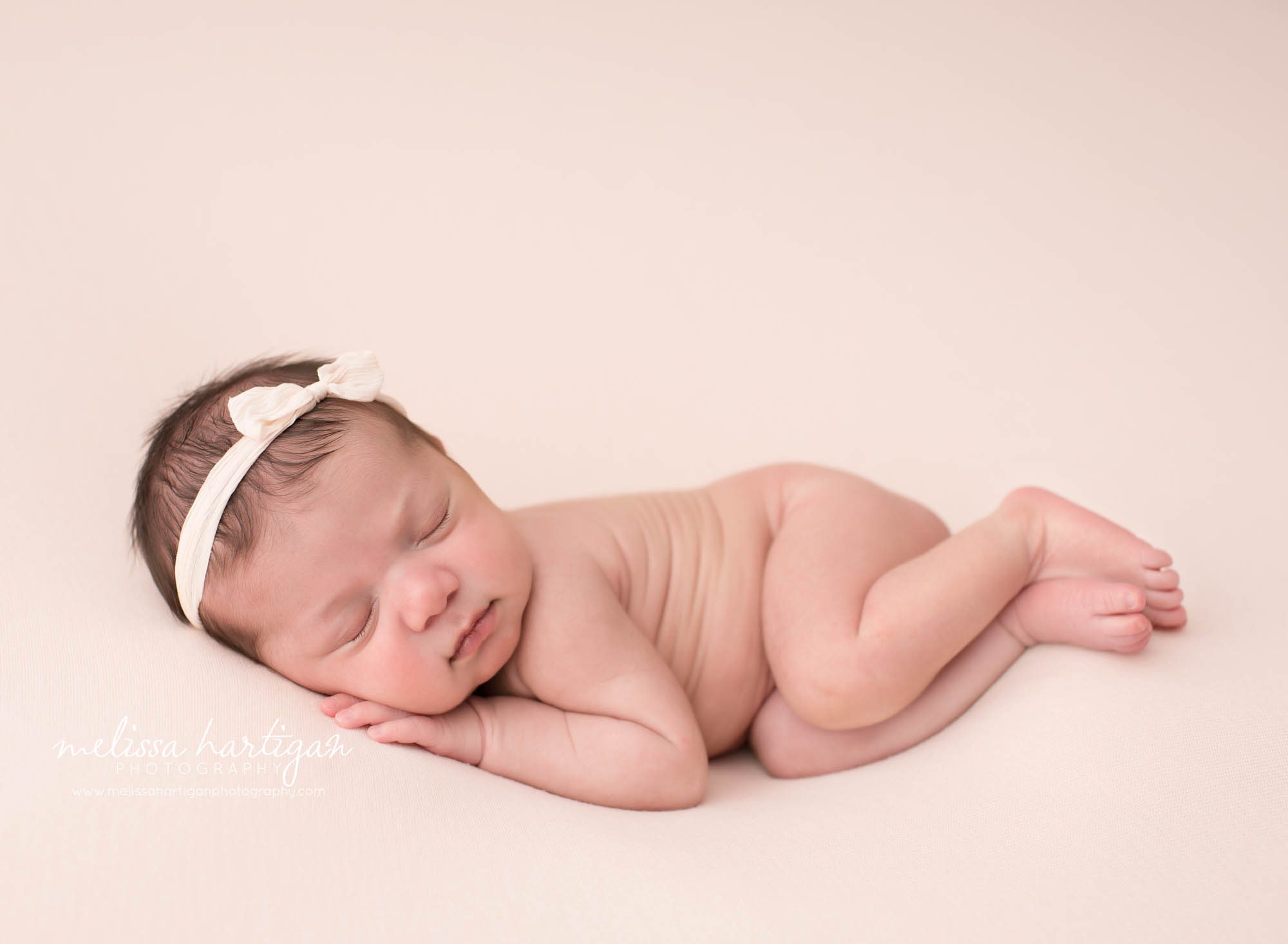 newborn baby girl posed on side on pink backdrop Newborn Photography West Hartford